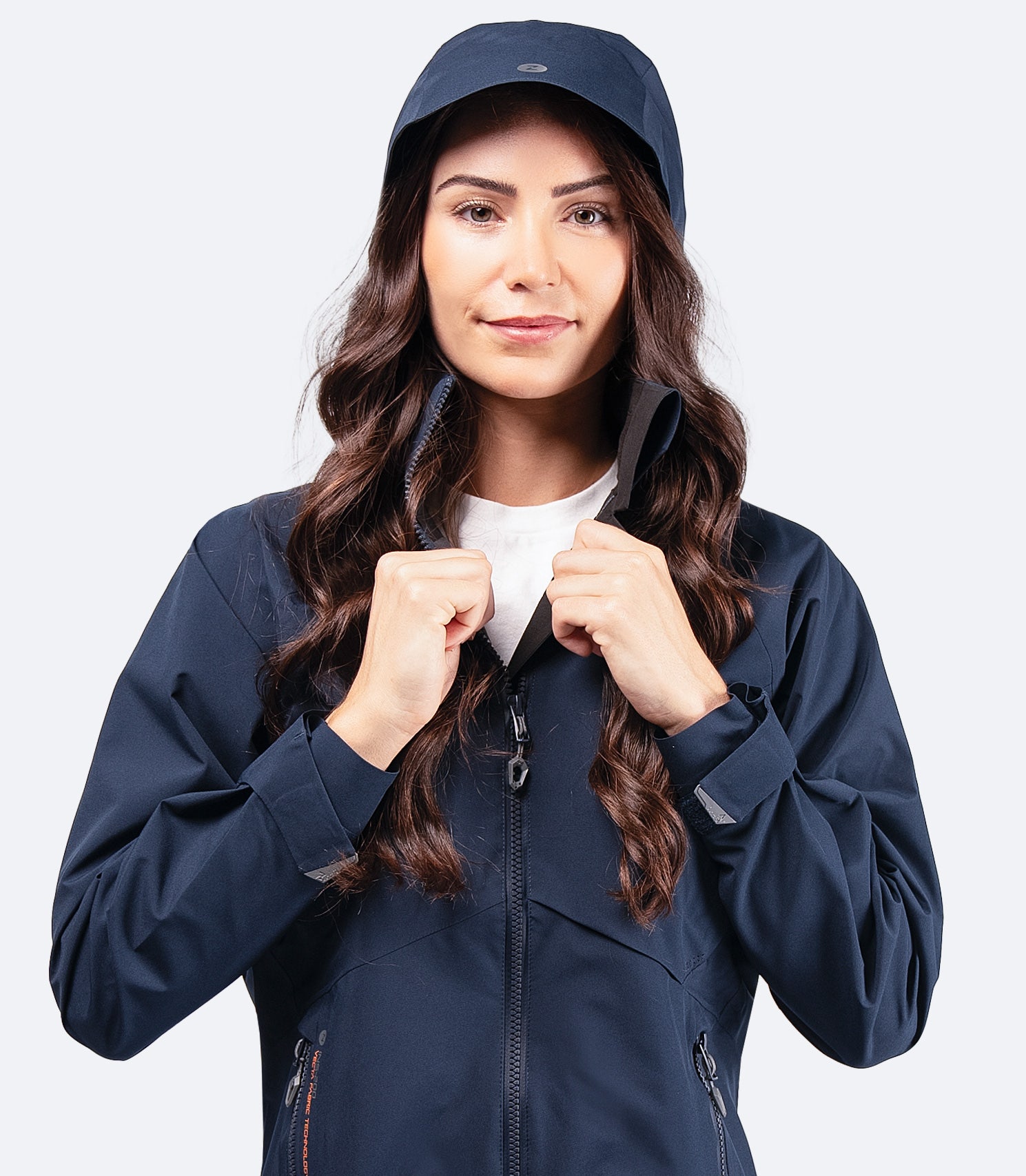 Zhik Women's Midnight Blue INS200 Jacket with hood up and high collar zipped, showcasing waterproof protection and ergonomic fit