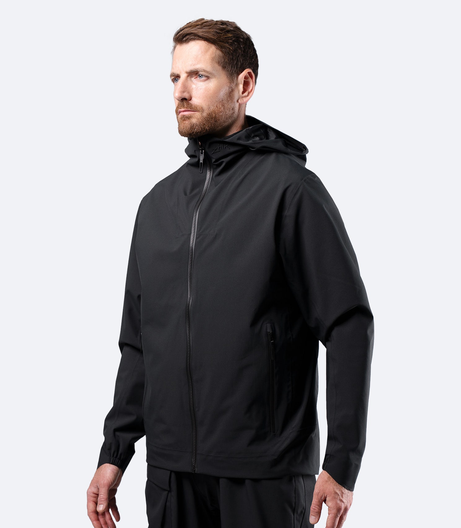 Zhik Men's INS300 Inshore Jacket in Black on male model, front view of lightweight waterproof shell