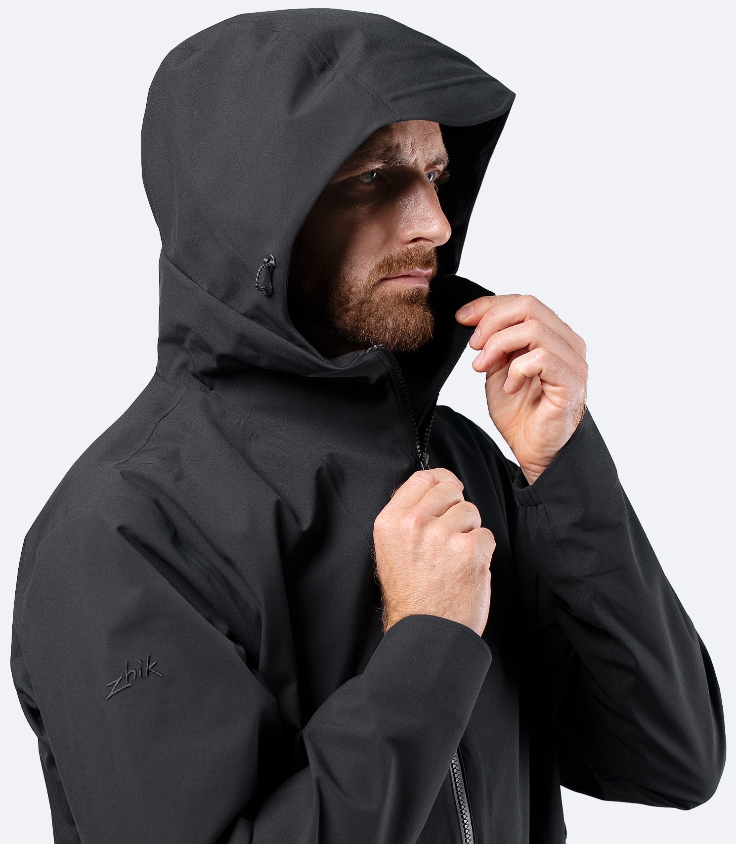 Side view of Zhik Men's INS300 Jacket in Black, hood up on male model, highlighting inshore weather protection