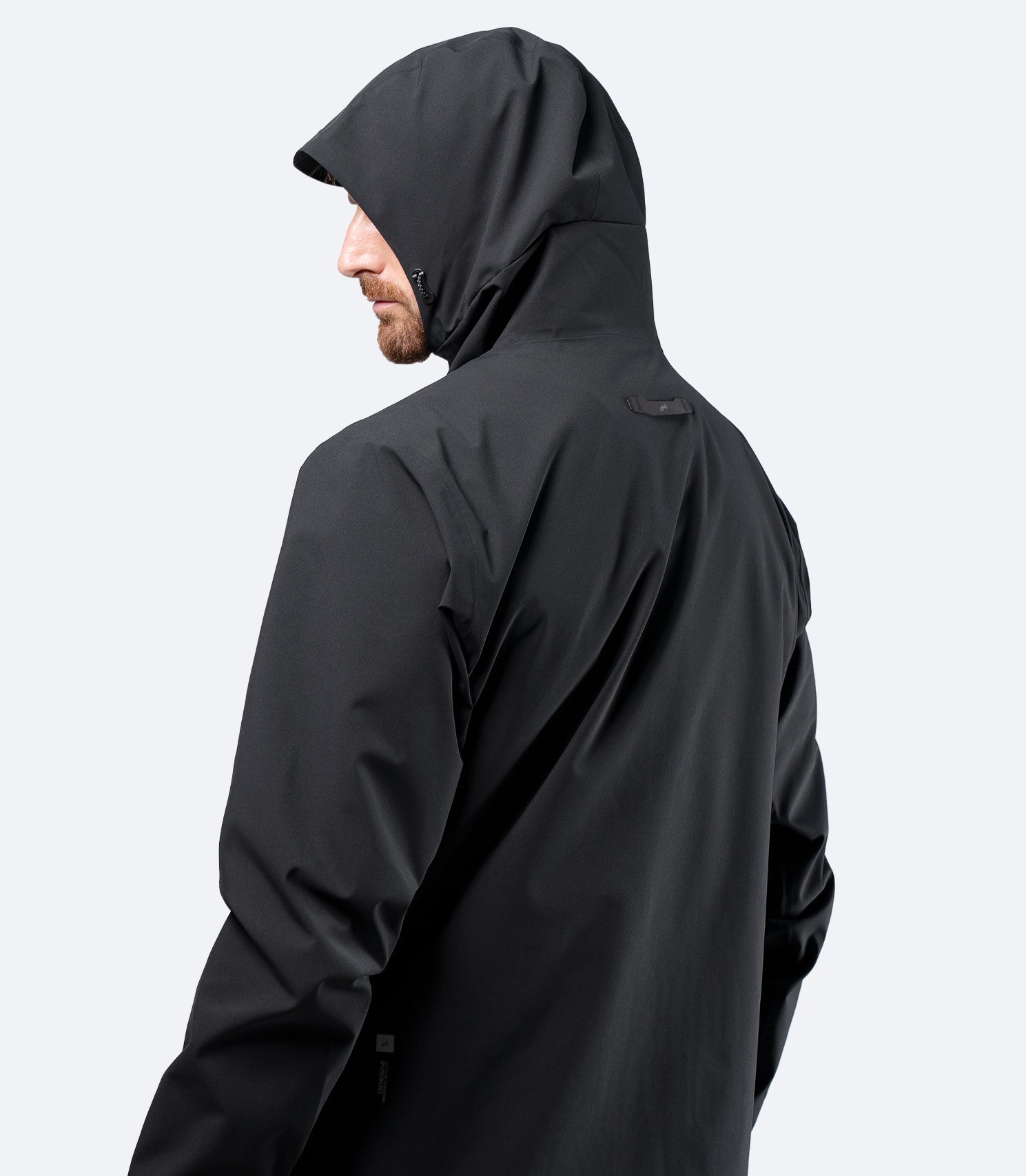 Rear view of Zhik Men's INS300 Jacket in Black with hood up, showing streamlined waterproof profile