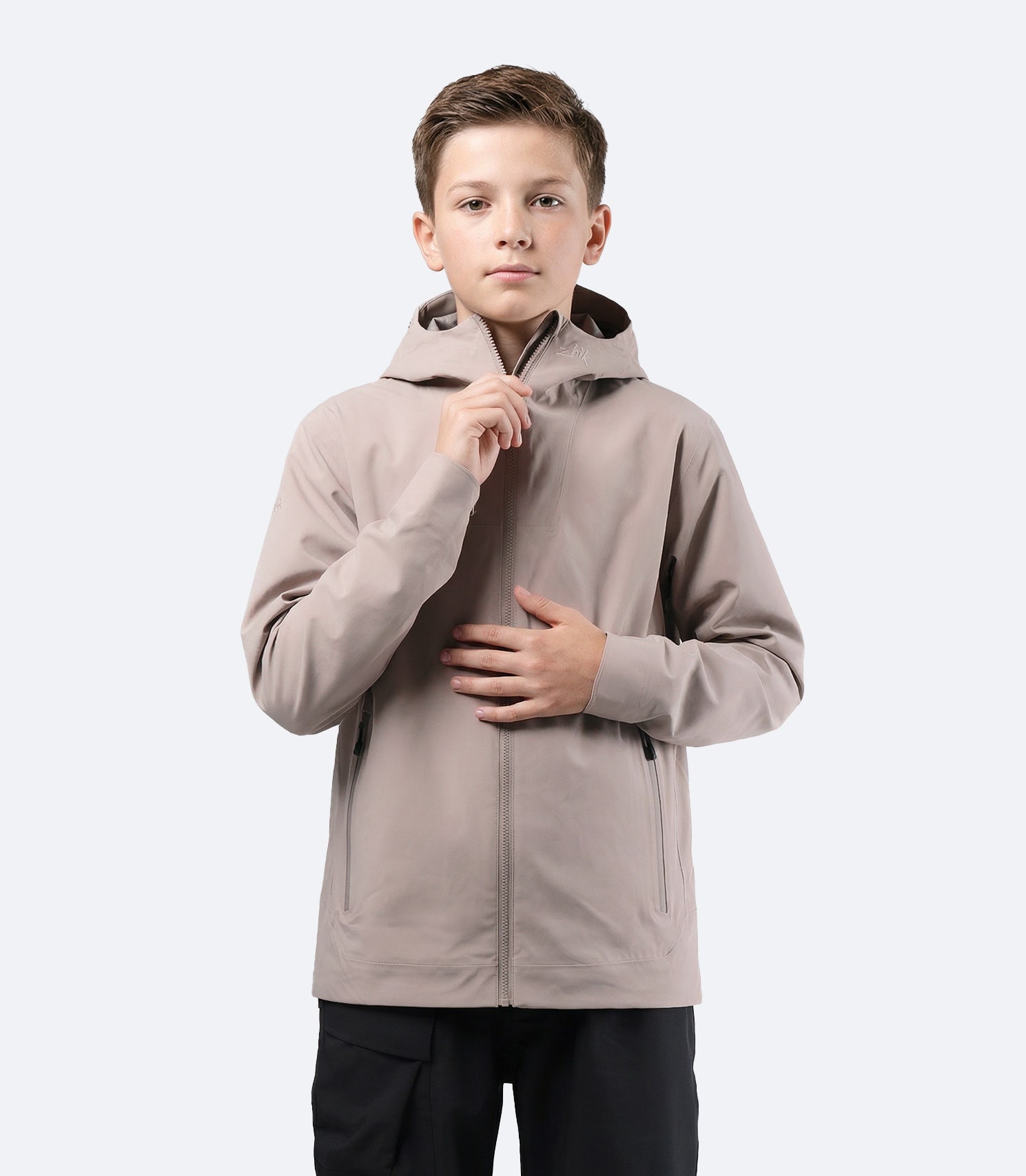 Vista frontal de la chaqueta Zhik Youth INS300 Inshore Active Jacket en color piedra, con cremallera frontal resistente al agua y un diseño limpio.