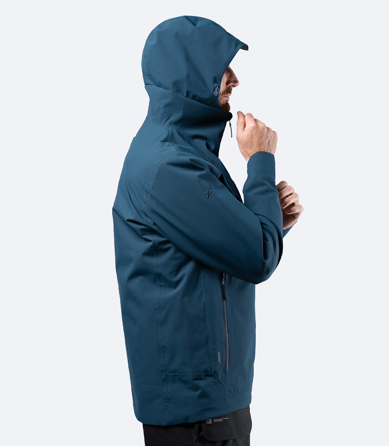 Side view of Zhik Men's INS300 Jacket in Deep Teal, hood up on male model, highlighting inshore weather protection