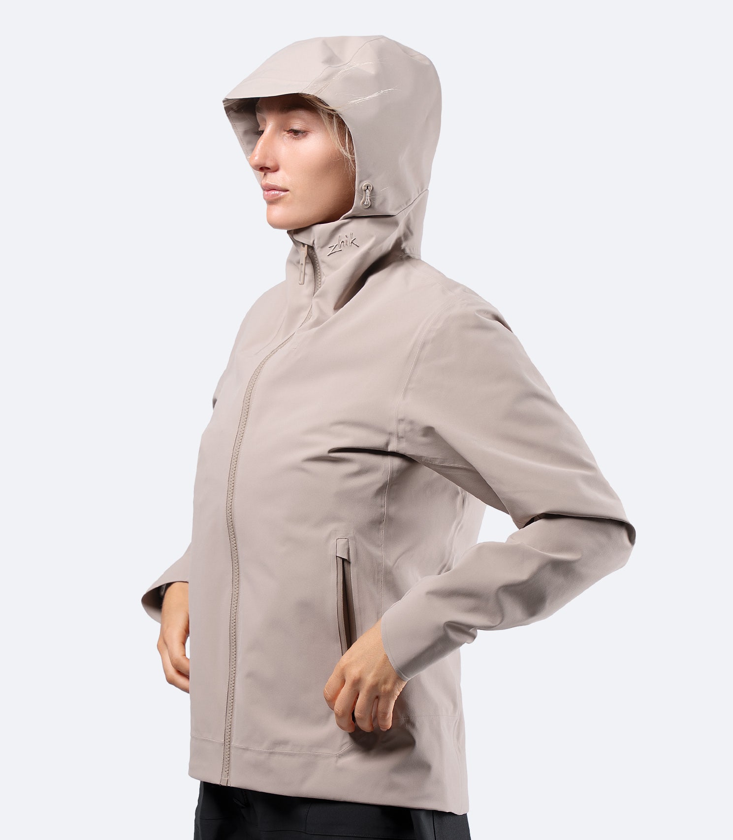 Side view of Zhik INS300 Women's Inshore Active Jacket in Stone, hood up with streamlined cut for active inshore use