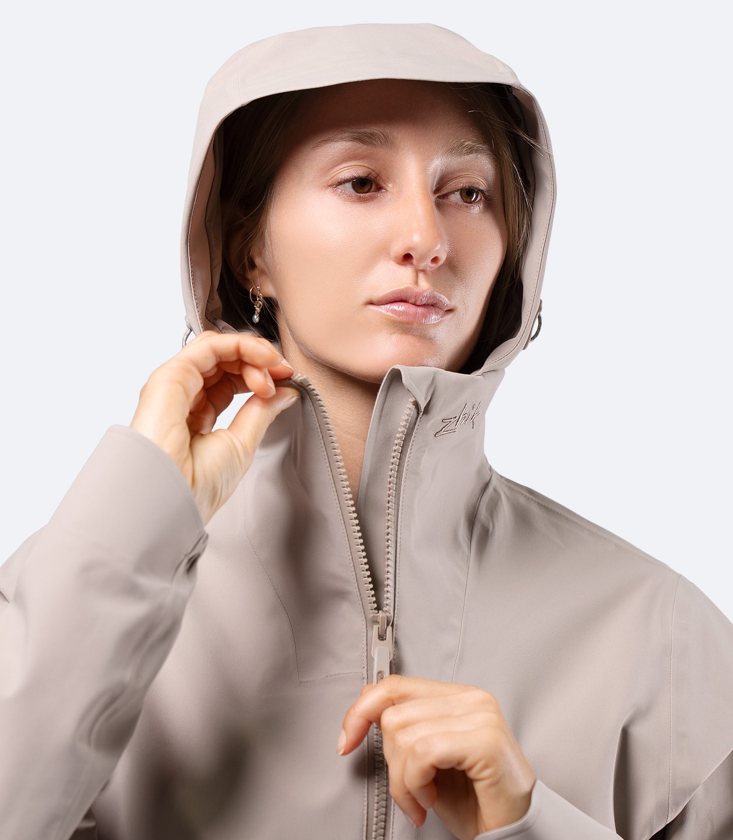 Close-up of Zhik INS300 Women's Inshore Active Jacket in Stone, hood up with zip top for protection from spray and wind