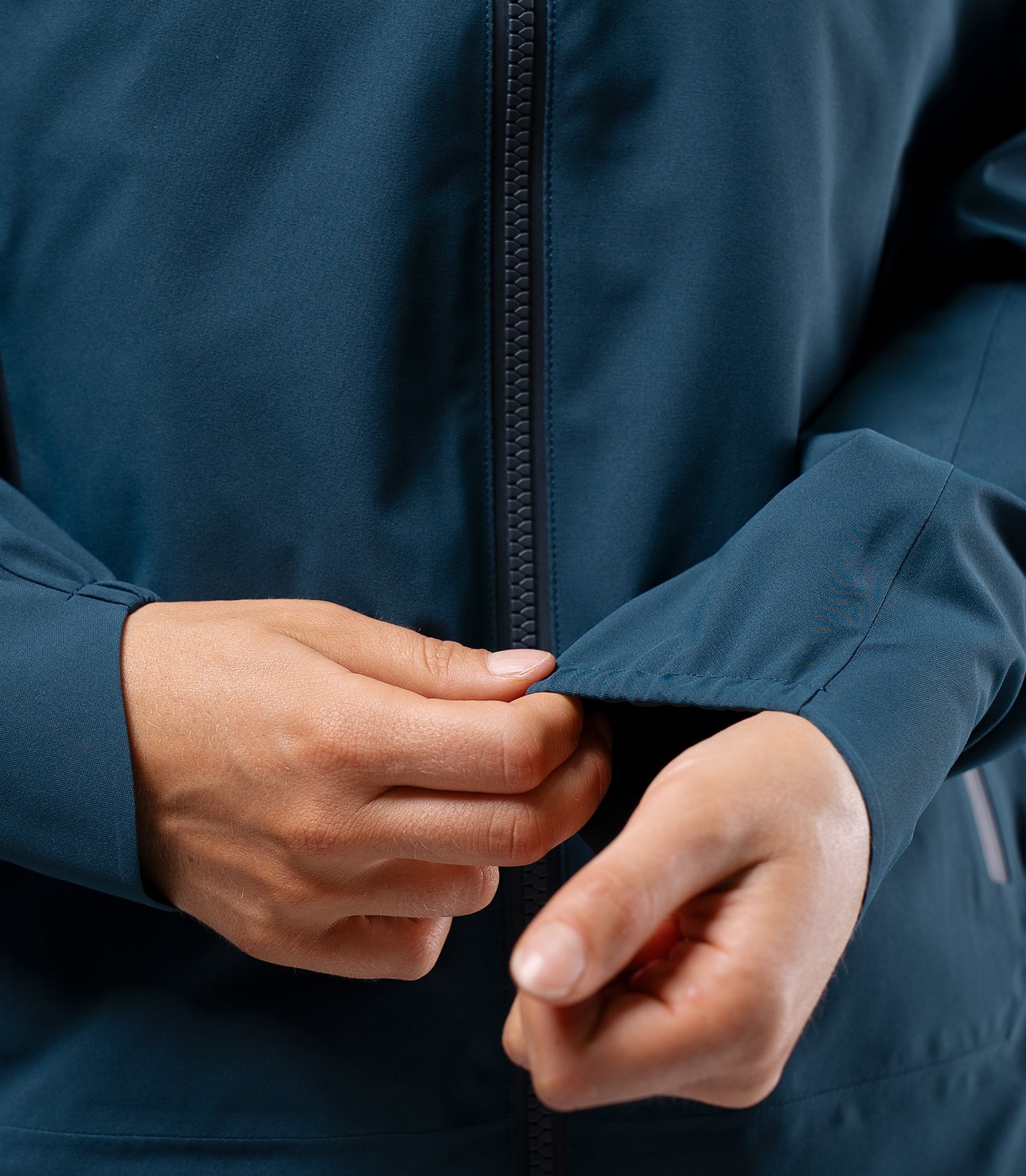 Close-up of sleeve on Zhik INS300 Women's Inshore Active Jacket in Deep Teal, with hand resting on cuff to show finish and fit