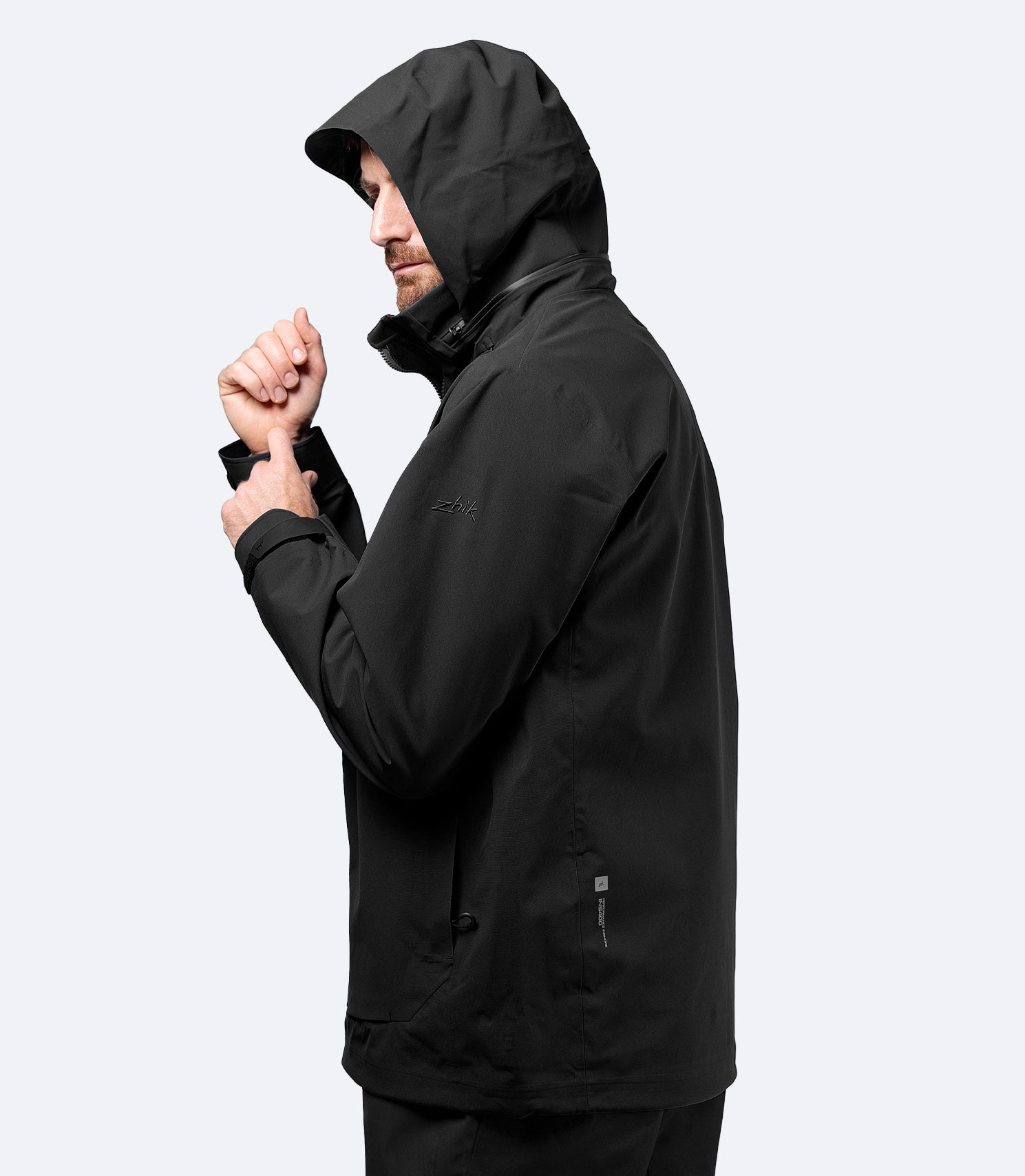 Side view of Zhik Men's Black INS400 inshore jacket with hood up, showcasing contoured fit and storm coverage