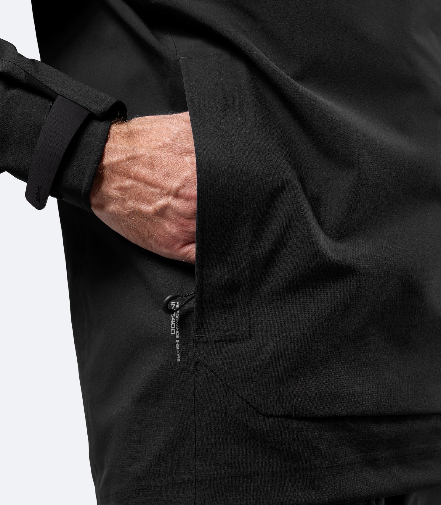 Close-up of front pocket on Zhik Men's Black INS400 inshore jacket with water-resistant zip and drainage