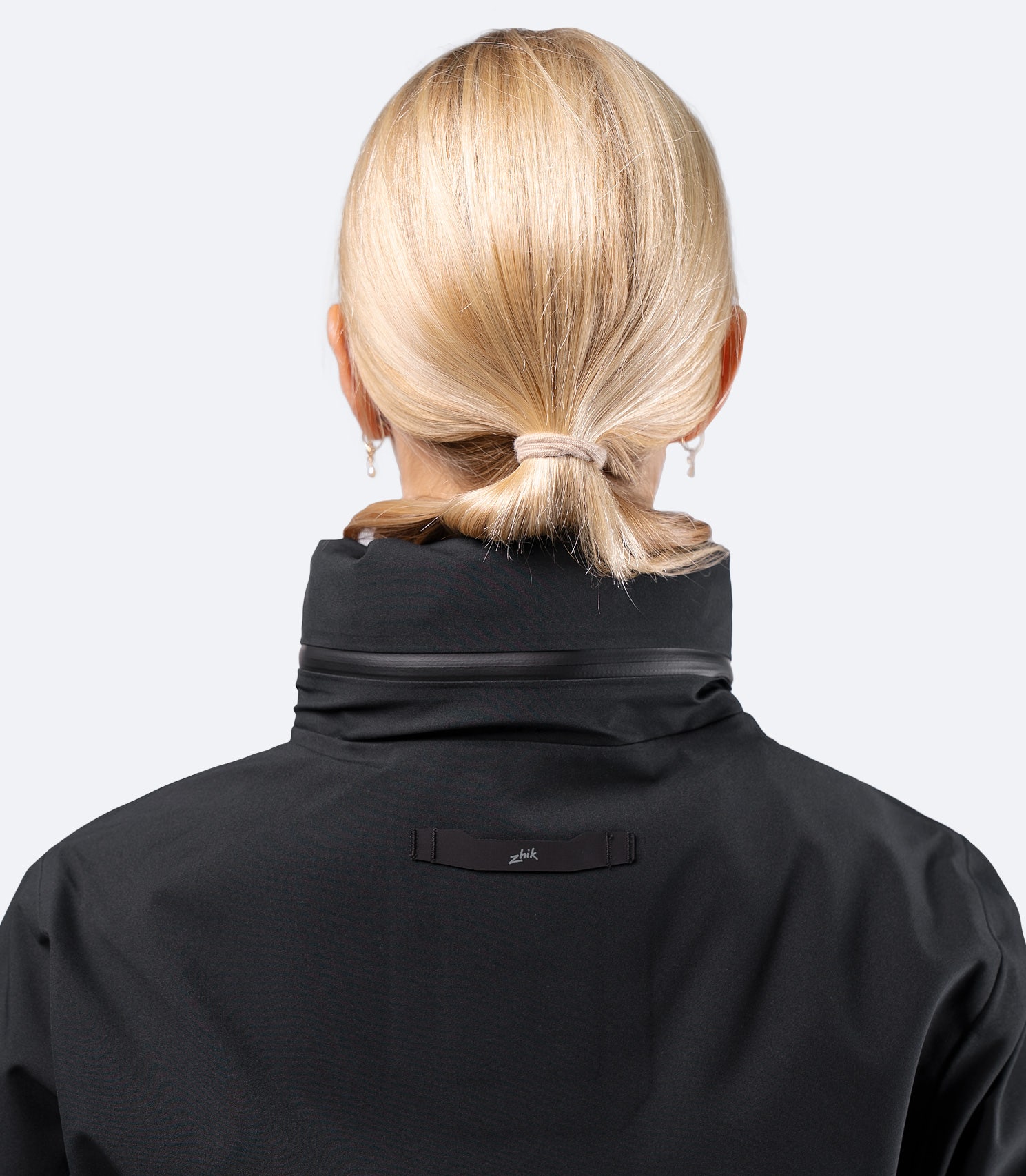 Zhik Women's INS400 jacket in Black, rear hood stowed with low profile zip pocket for packable storage