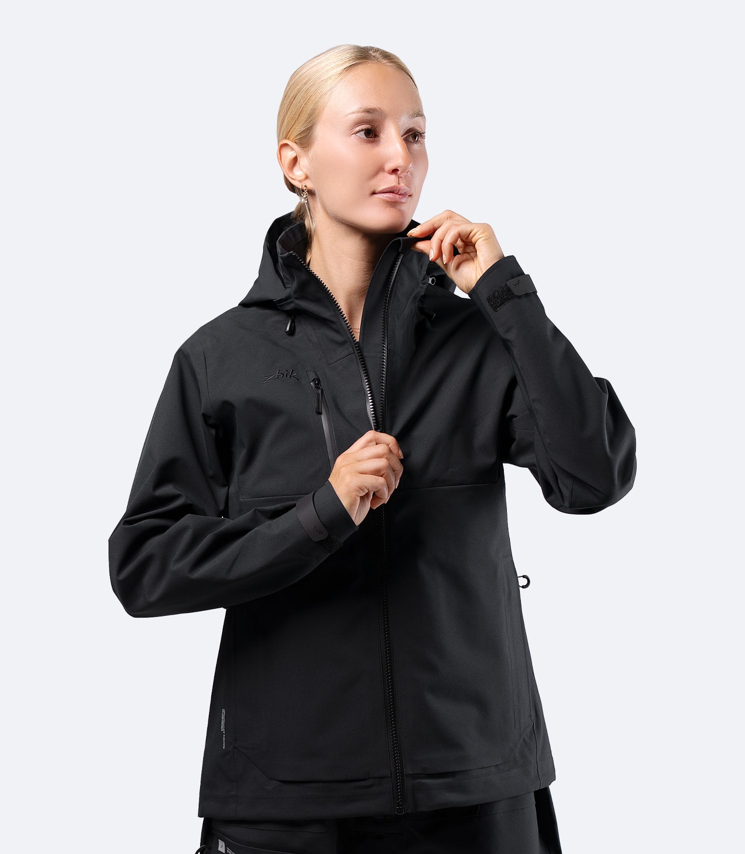 Zhik Women's INS400 inshore jacket in Black on female model, hood down, showing streamlined sports cut