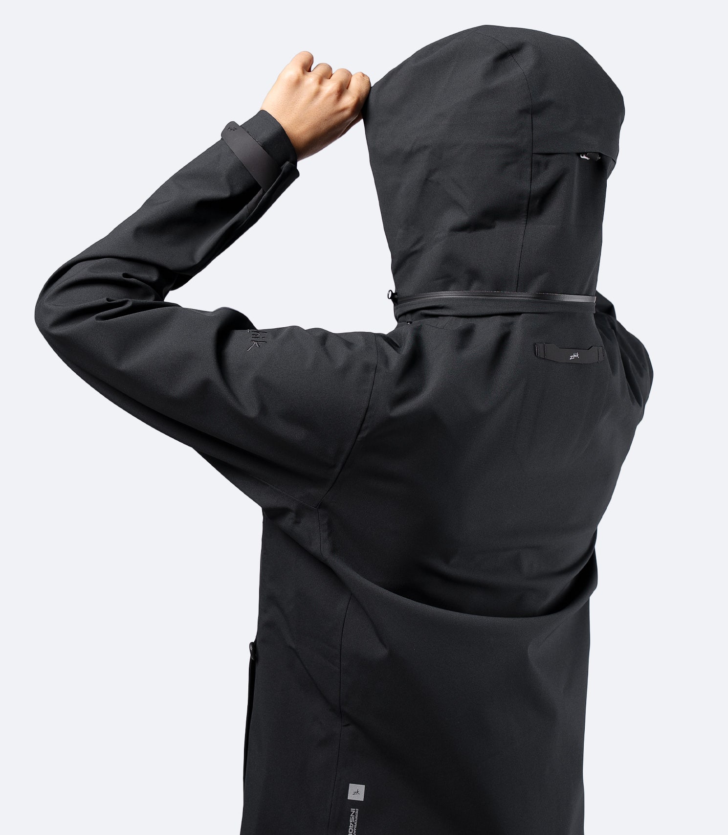 Back view of Zhik Women's INS400 jacket in Black with hood up, showing articulated arms and clean lines