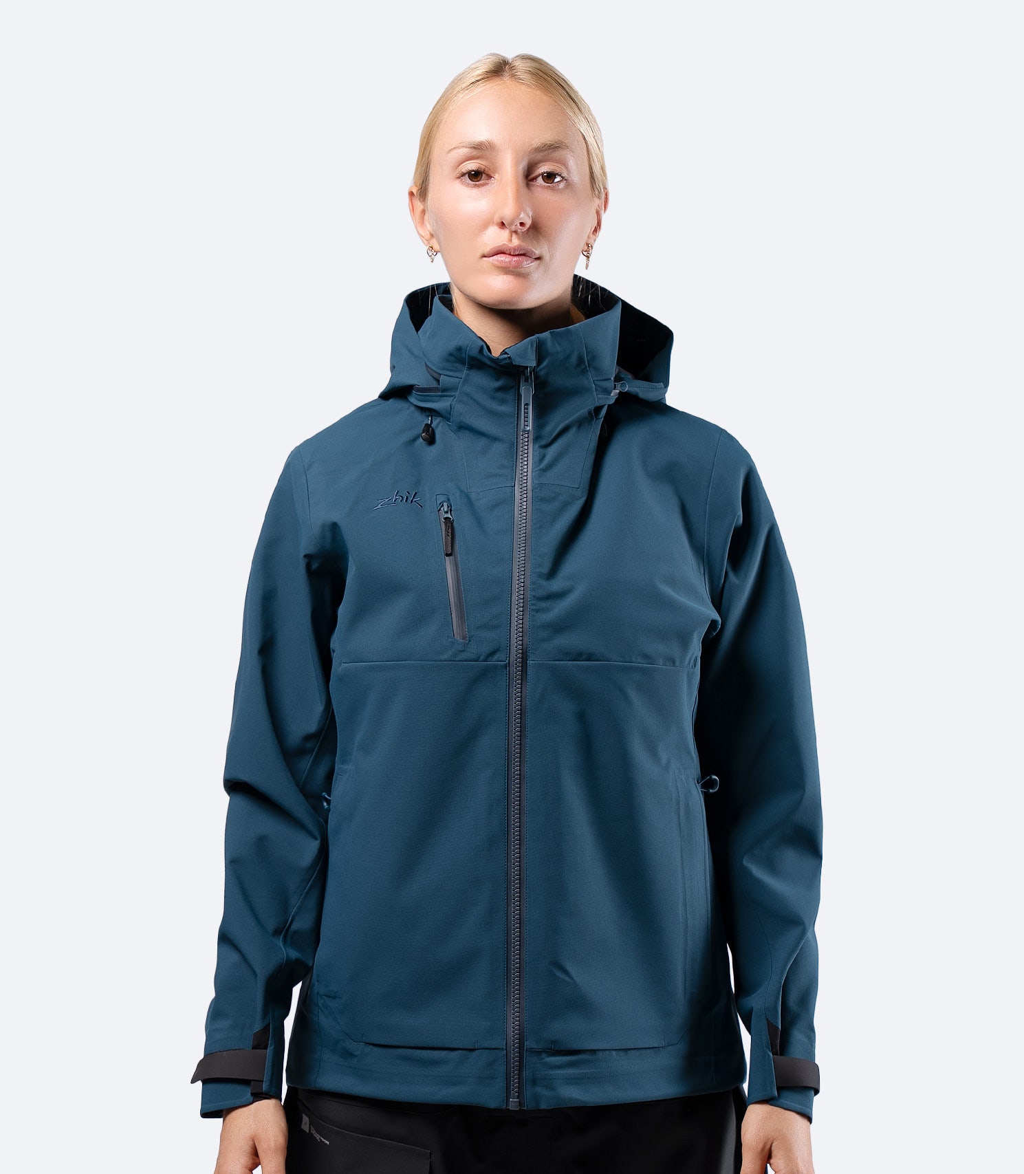Zhik Women's INS400 inshore jacket in Deep Teal on female model, hood down, showing streamlined sports cut