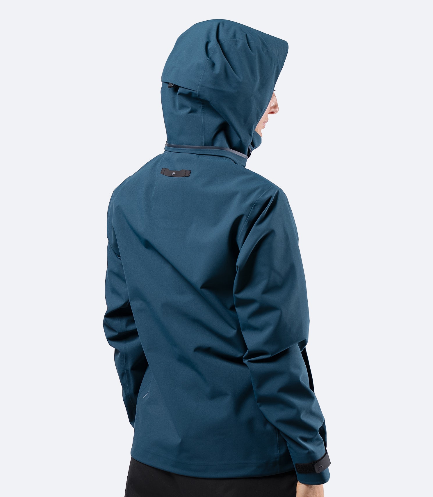 Back view of Zhik Women's INS400 jacket in Deep Teal with hood up, showing articulated arms and clean lines