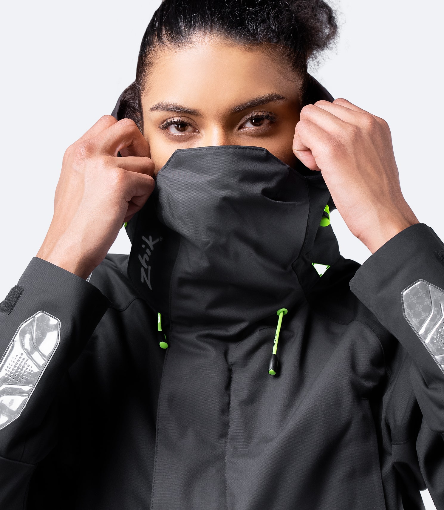 Front view of Zhik Women's Black OFS700 Jacket with hood down, collar up, and reflective wrist details for visibility in low light.