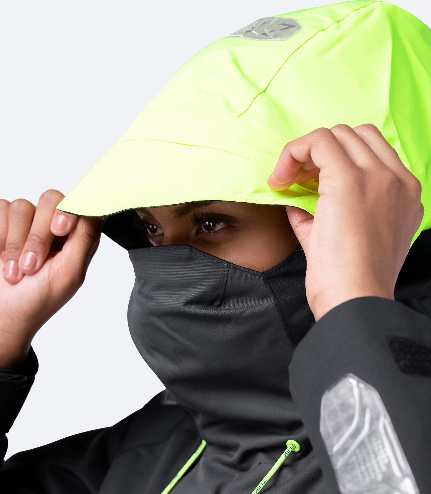 Side view of Zhik Women's Black OFS700 Jacket with hood on, showing high collar and ergonomic fit for offshore protection.