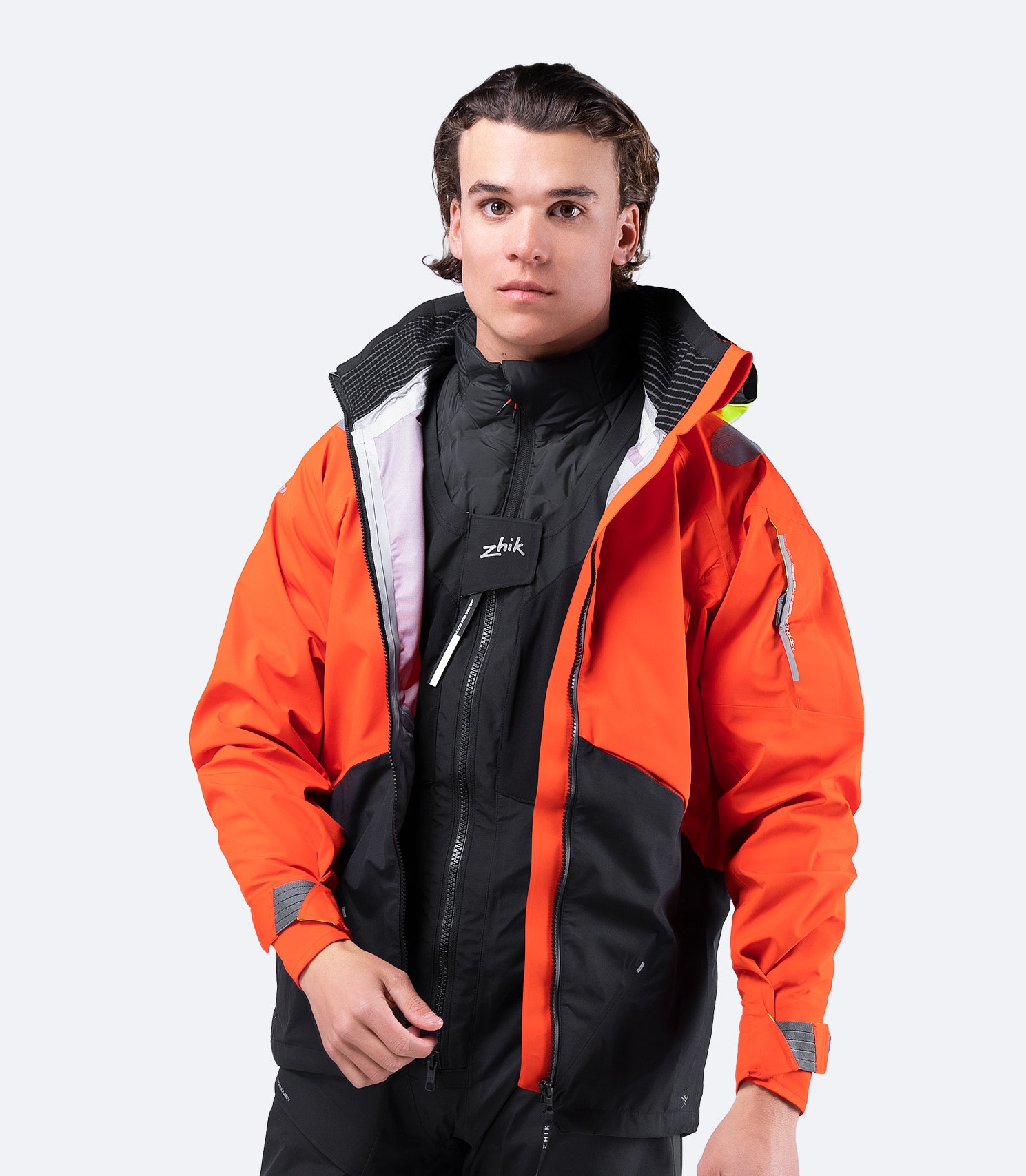 Front view of model wearing Zhik Men's CST500™ Jacket in Flame Red with zipper open, showing lightweight fit for casual wear.