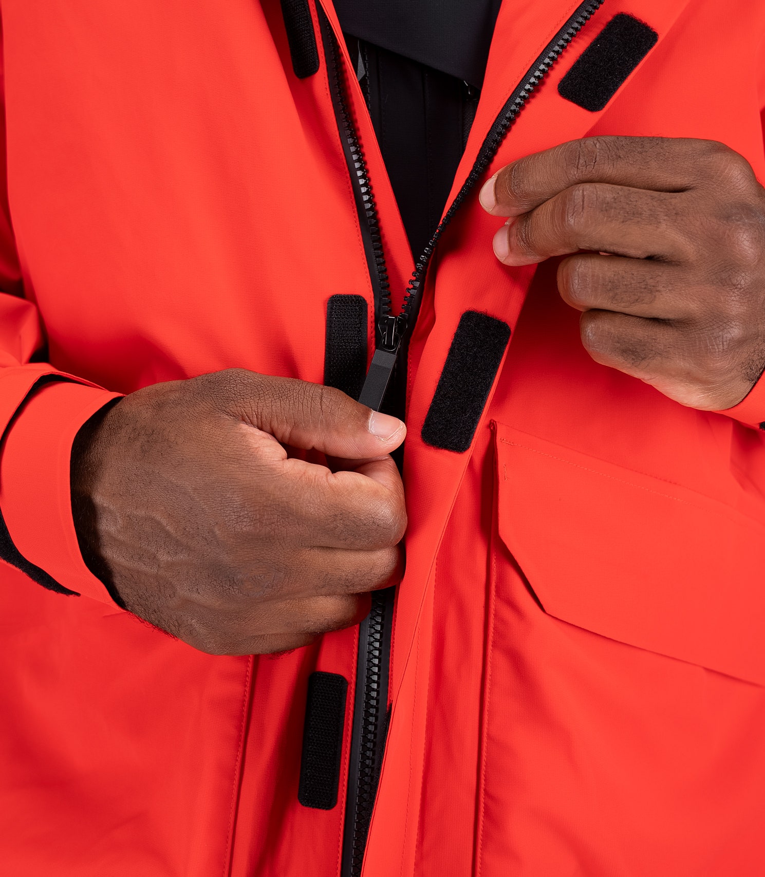 Close-up of flame red OFS600 Jacket chest zipper with water-resistant seal and internal placket for added weather protection.