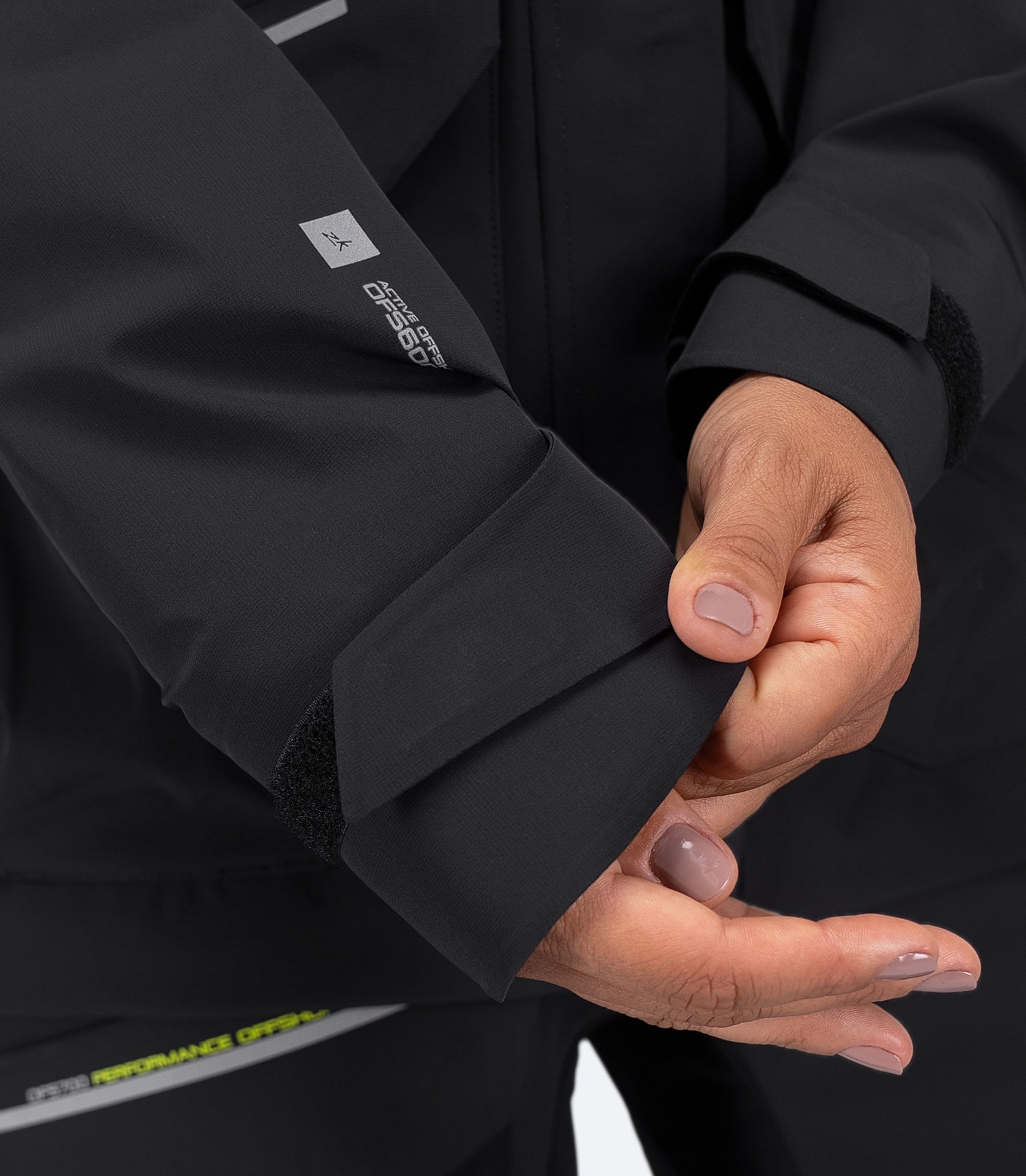 Zhik Women's OFS600 Offshore Jacket in black, close-up of adjustable wrist with Velcro tab and secure waterproof seal.