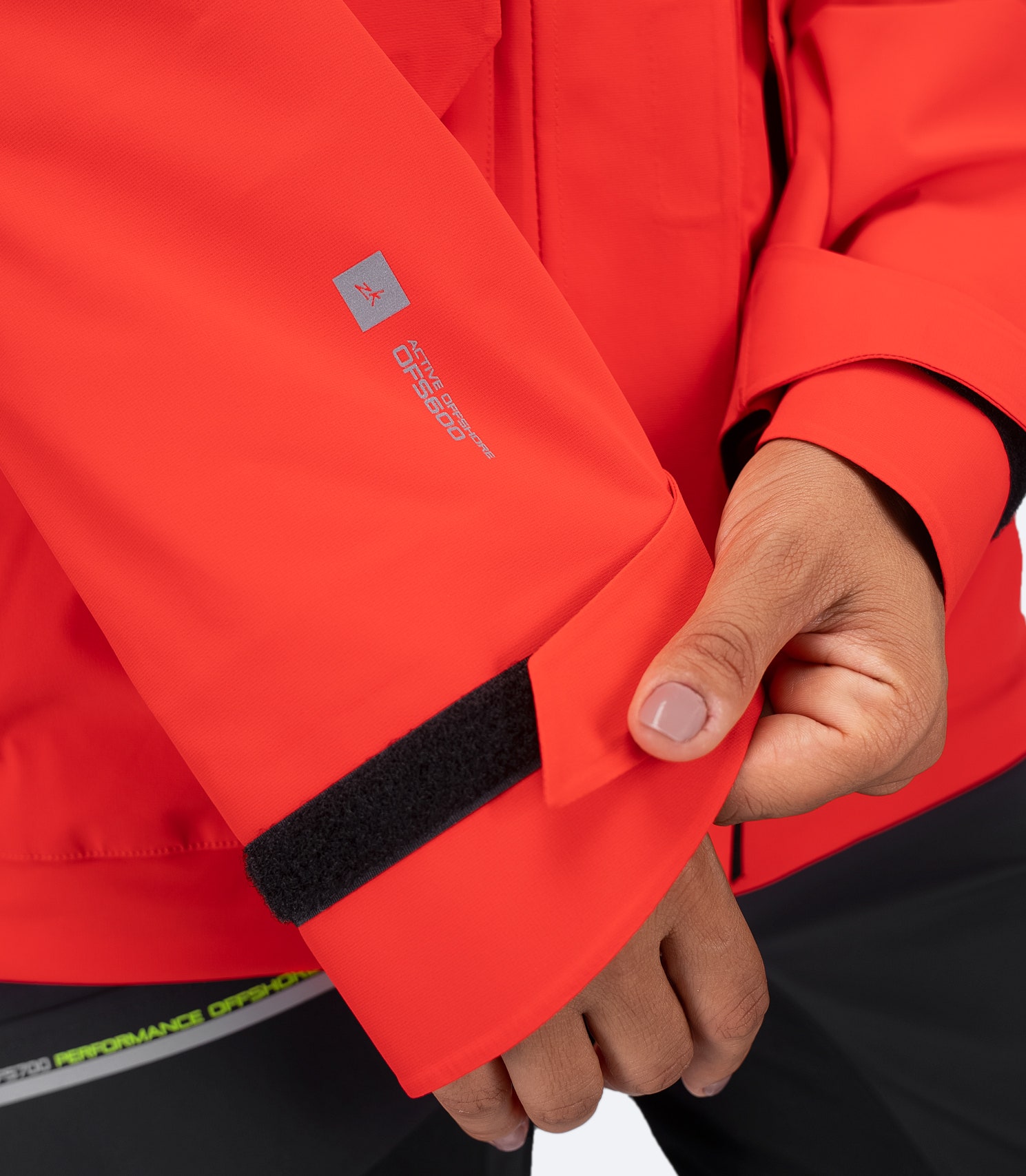 Zhik Women's OFS600 Jacket in flame red, close-up of Velcro-adjustable wrist closure for a secure weatherproof seal.