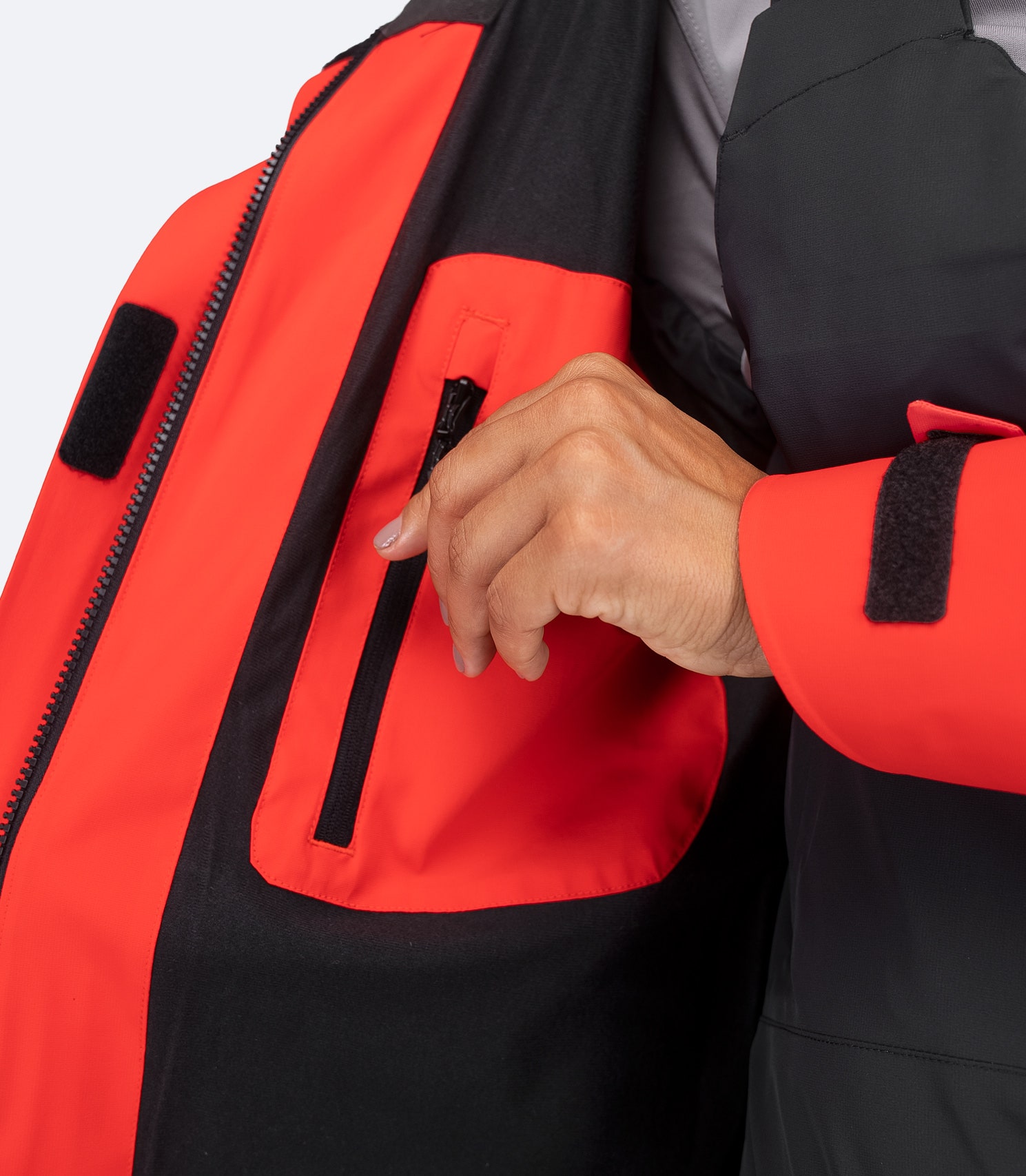 Interior close-up of Zhik Women's OFS600 Jacket in flame red, showing zippered chest pocket for valuables.