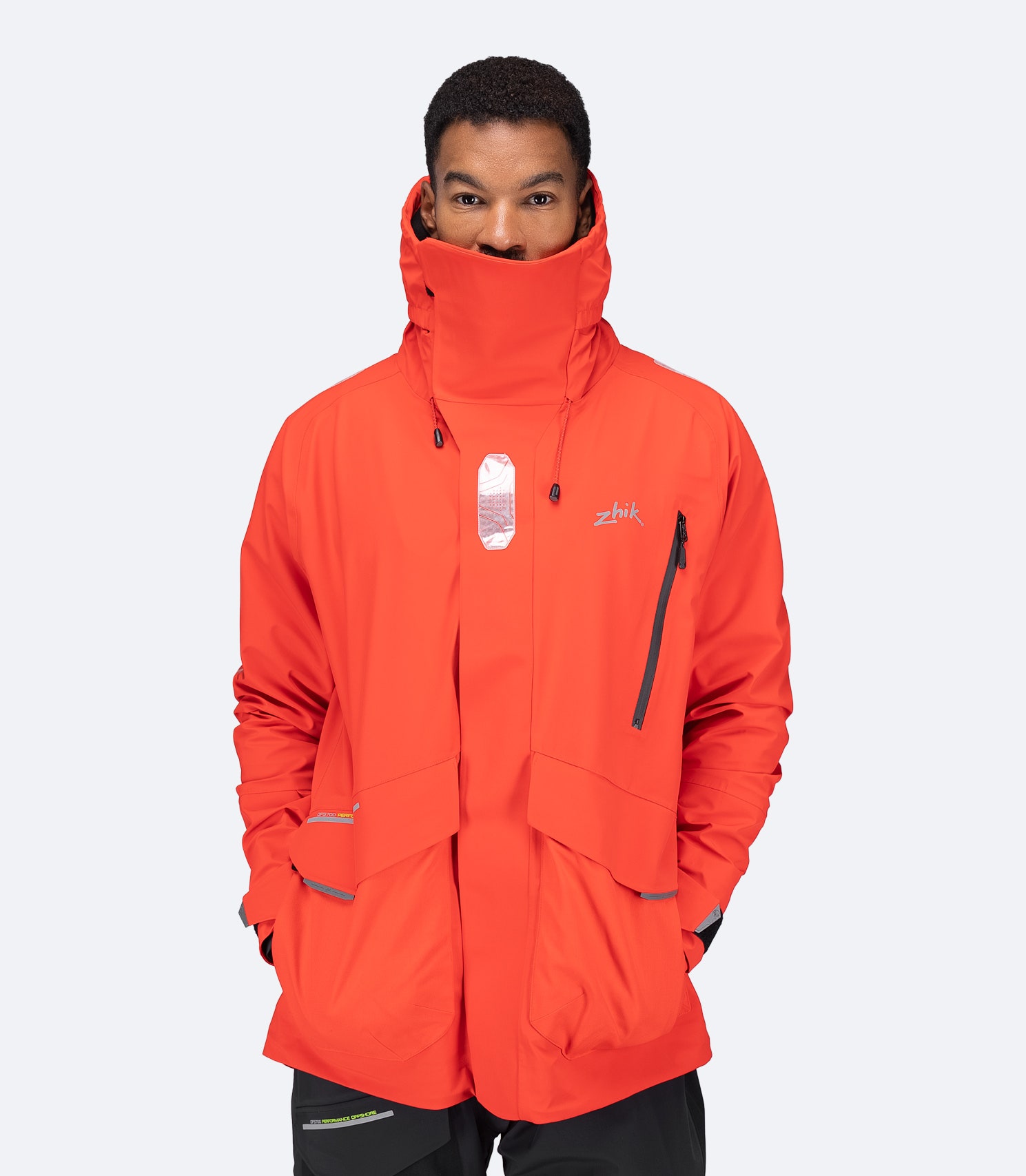 Flame red OFS700 Jacket with storm collar raised and hood stowed, showing waterproof chest zip.