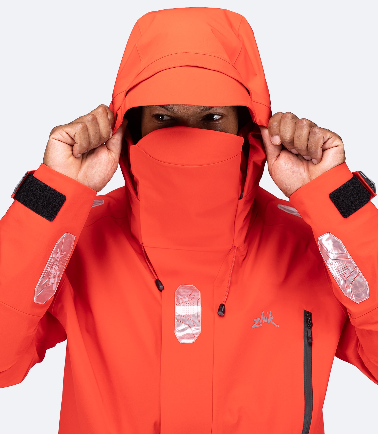 Close-up of flame red OFS700 Jacket with hood on, visor up, and high storm collar for protection.