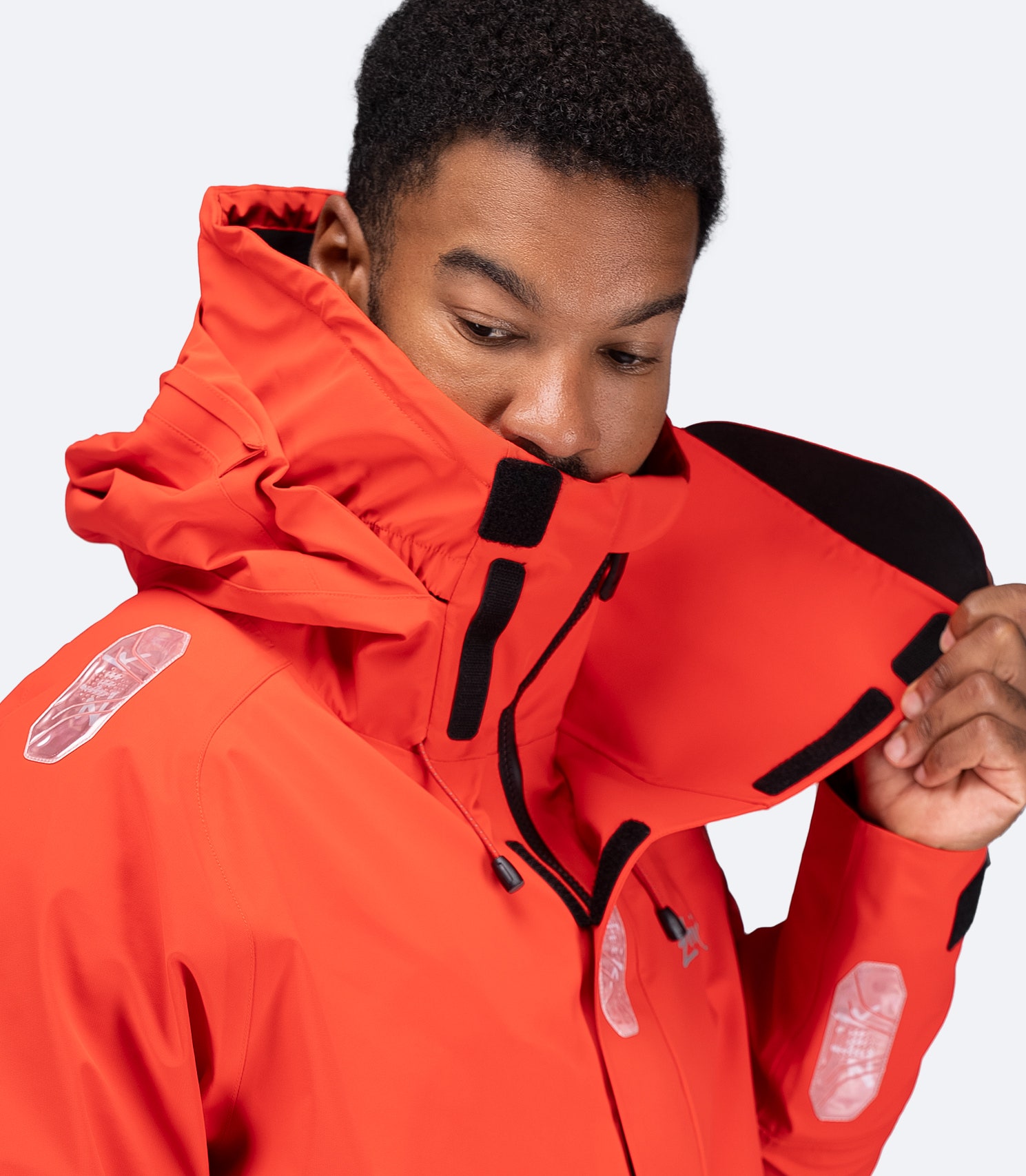 Diagonal close-up of flame red OFS700 Jacket showing inner velcro flap and breathable 3-layer fabric.