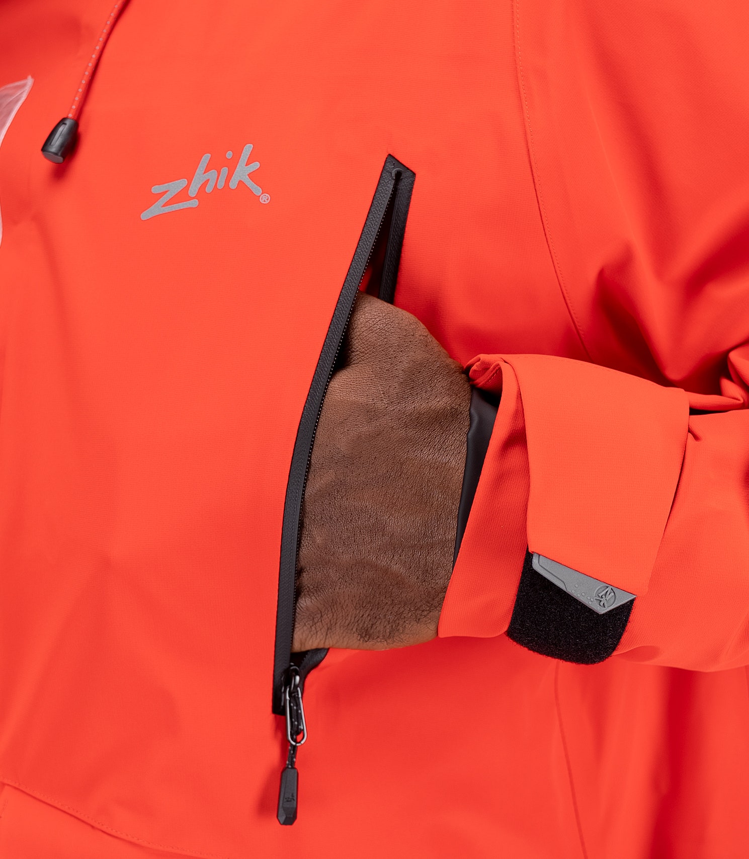 Close-up of chest pocket on flame red OFS700 Jacket with waterproof zip and bonded seam detail.