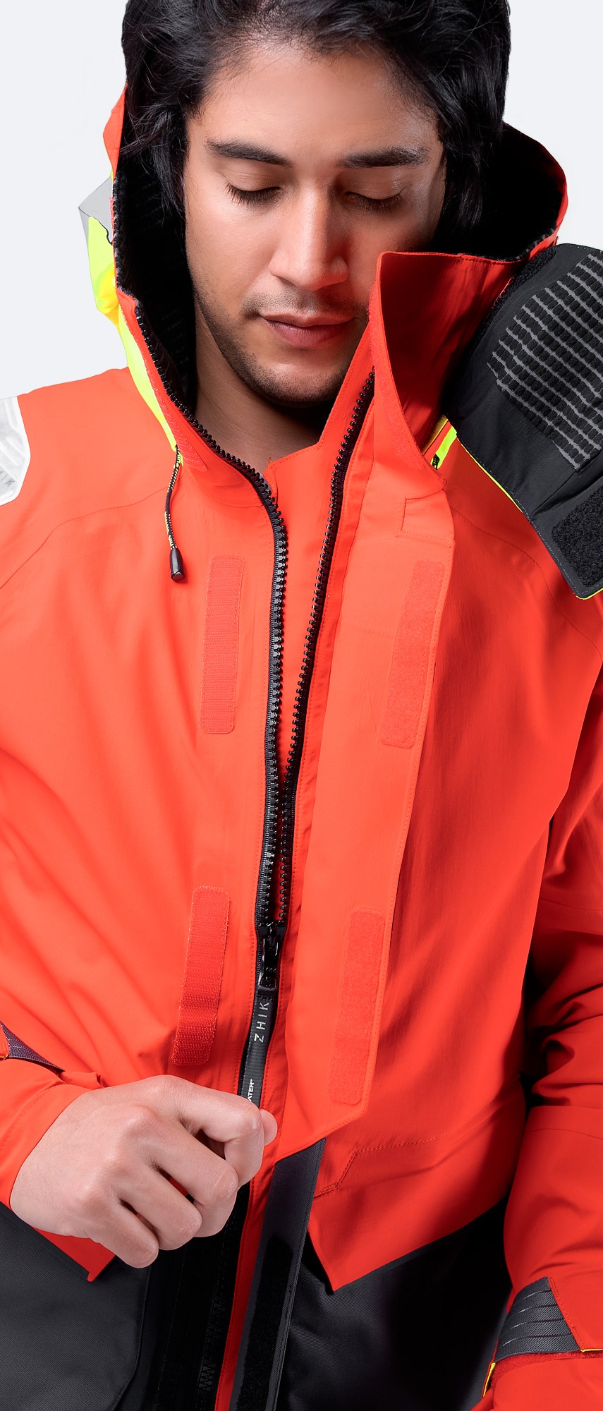 Front zipper close-up of Zhik OFS800™ Jacket in Flame Red, highlighting YKK® Vislon® zip with protective storm flap for flexibility.
