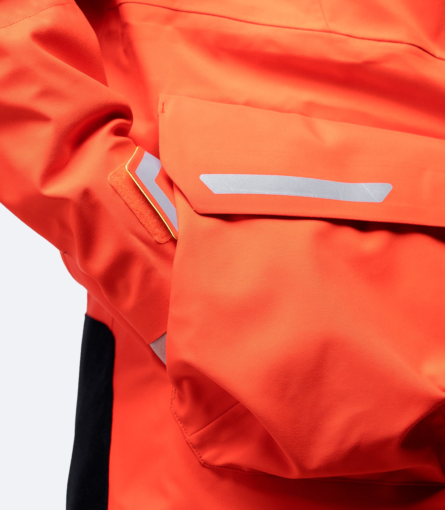 Close-up of front pocket on flame red Zhik Isotak X Jacket, featuring Hydrobase® lining for fast-drying warmth and secure storage.
