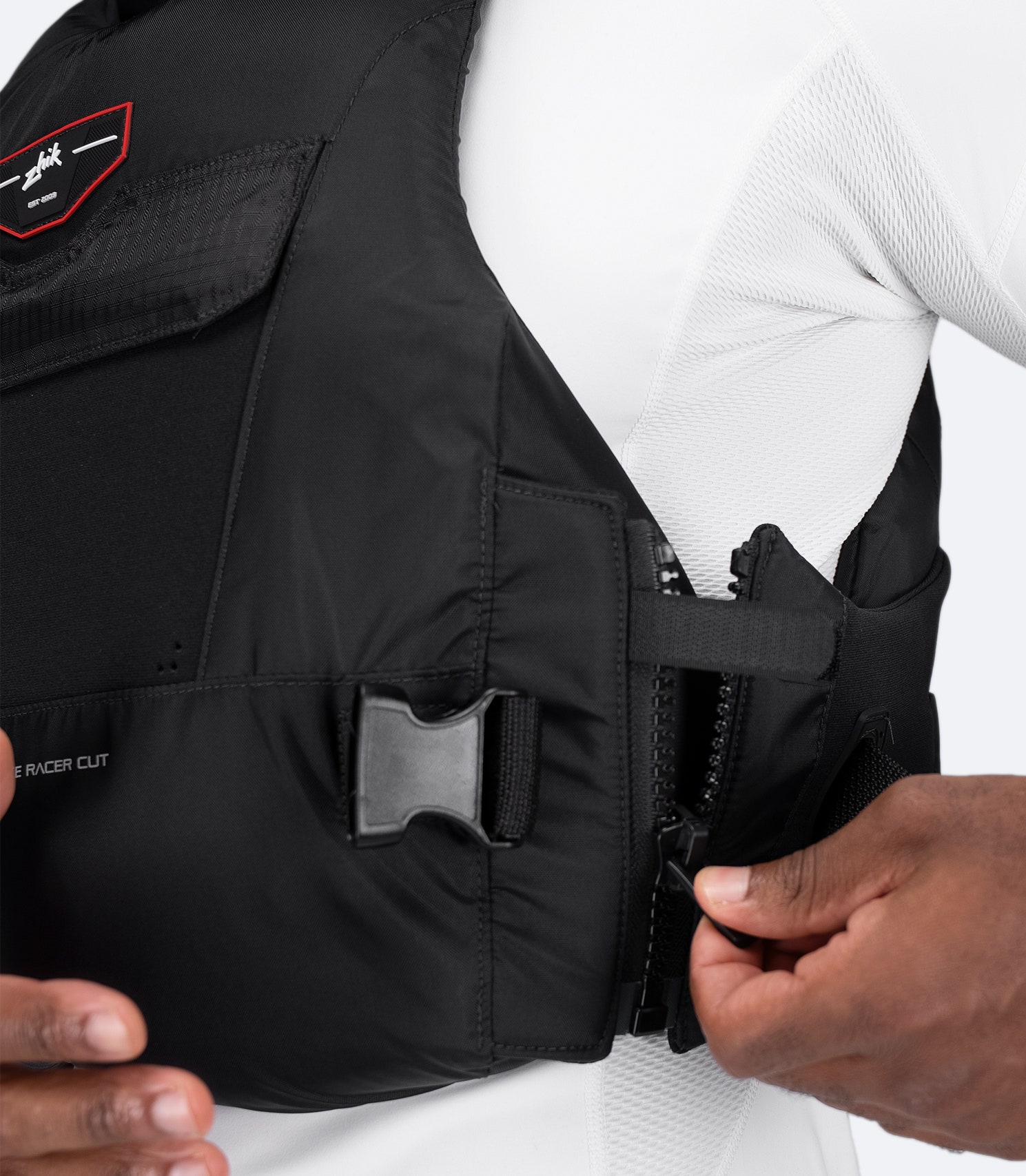 Close-up of black Zhik Racecut PFD side zip entry and waist buckle, designed for minimal bulk and secure fit.