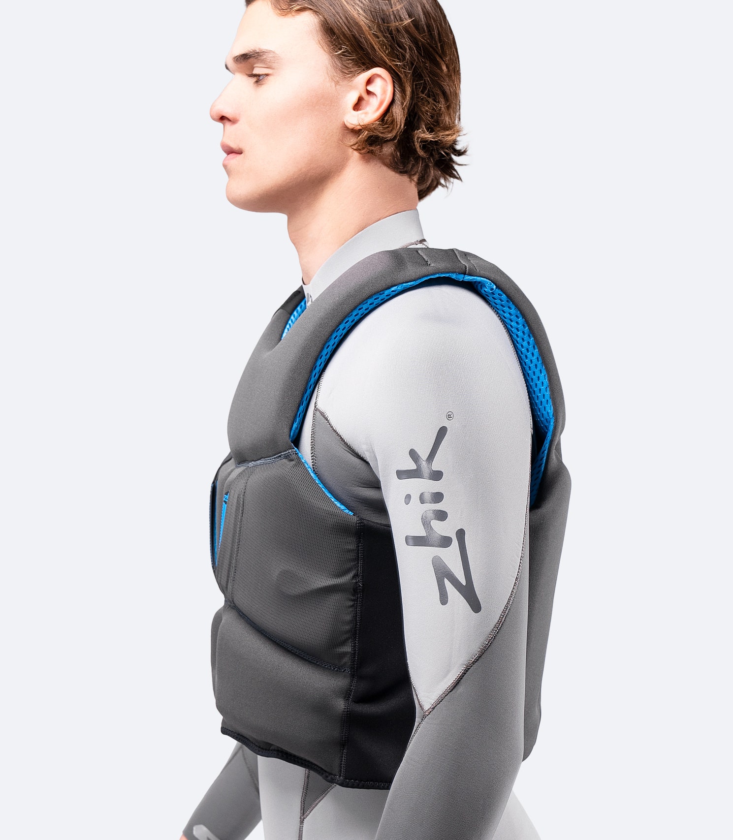 Side view of Zhik P2 PFD in grey, showing body-contoured fit, side zipper entry, and breathable mesh panels.