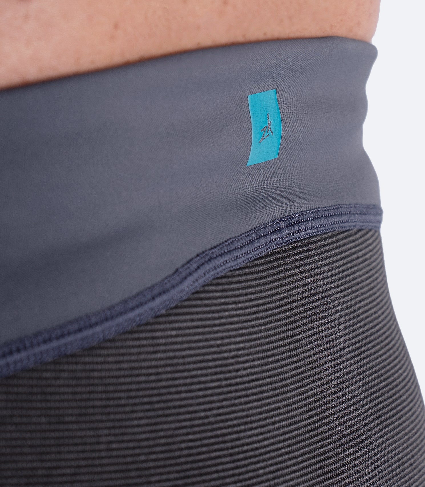 Close-up of subtle Zhik logo on the waist of Grey Hybrid Gear™ Performance Pants.