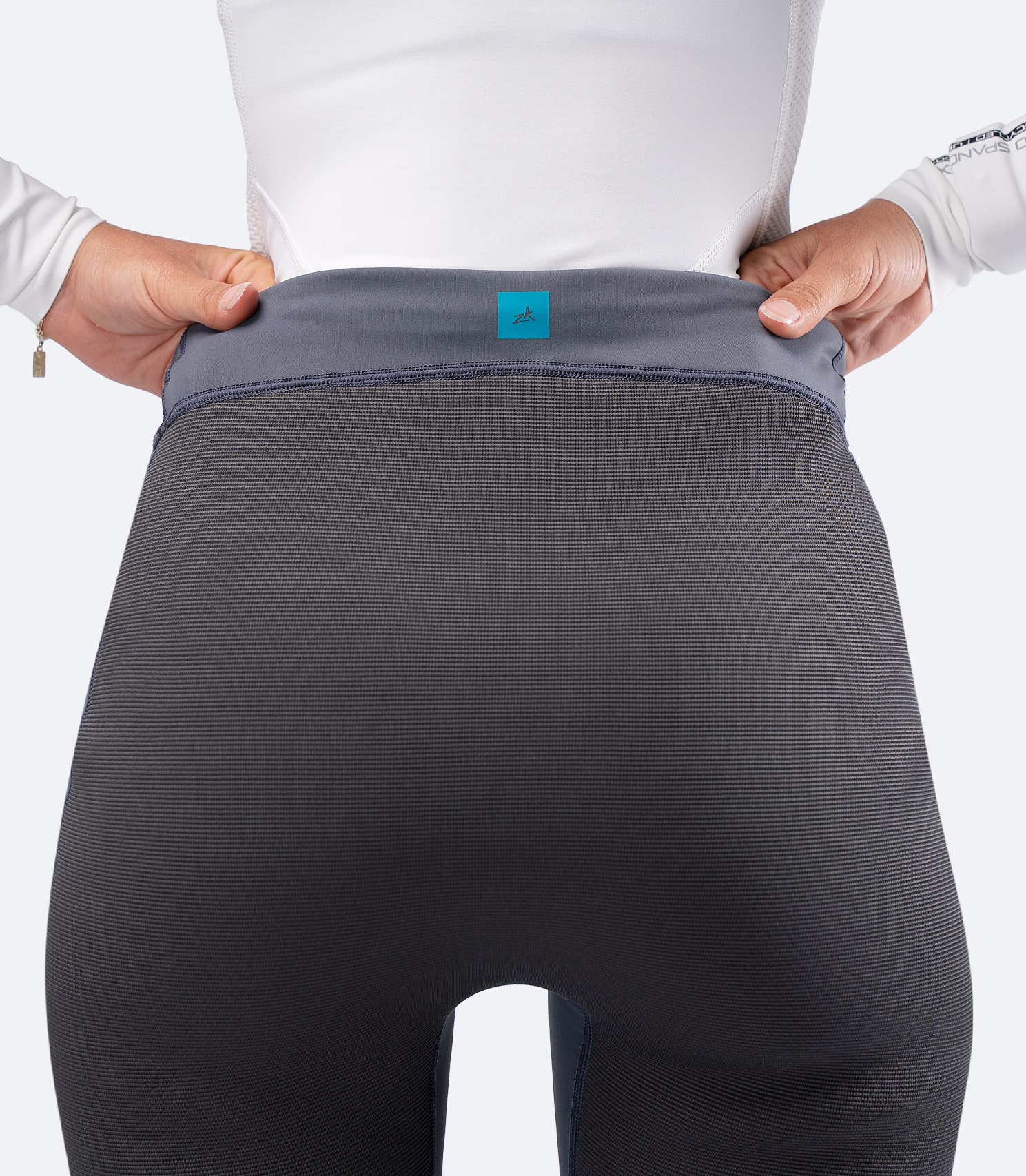 Close-up of Zhik Women's Hybrid Gear Performance Pants in Grey, showing reinforced seat padding and ZhikTex II abrasion panel.