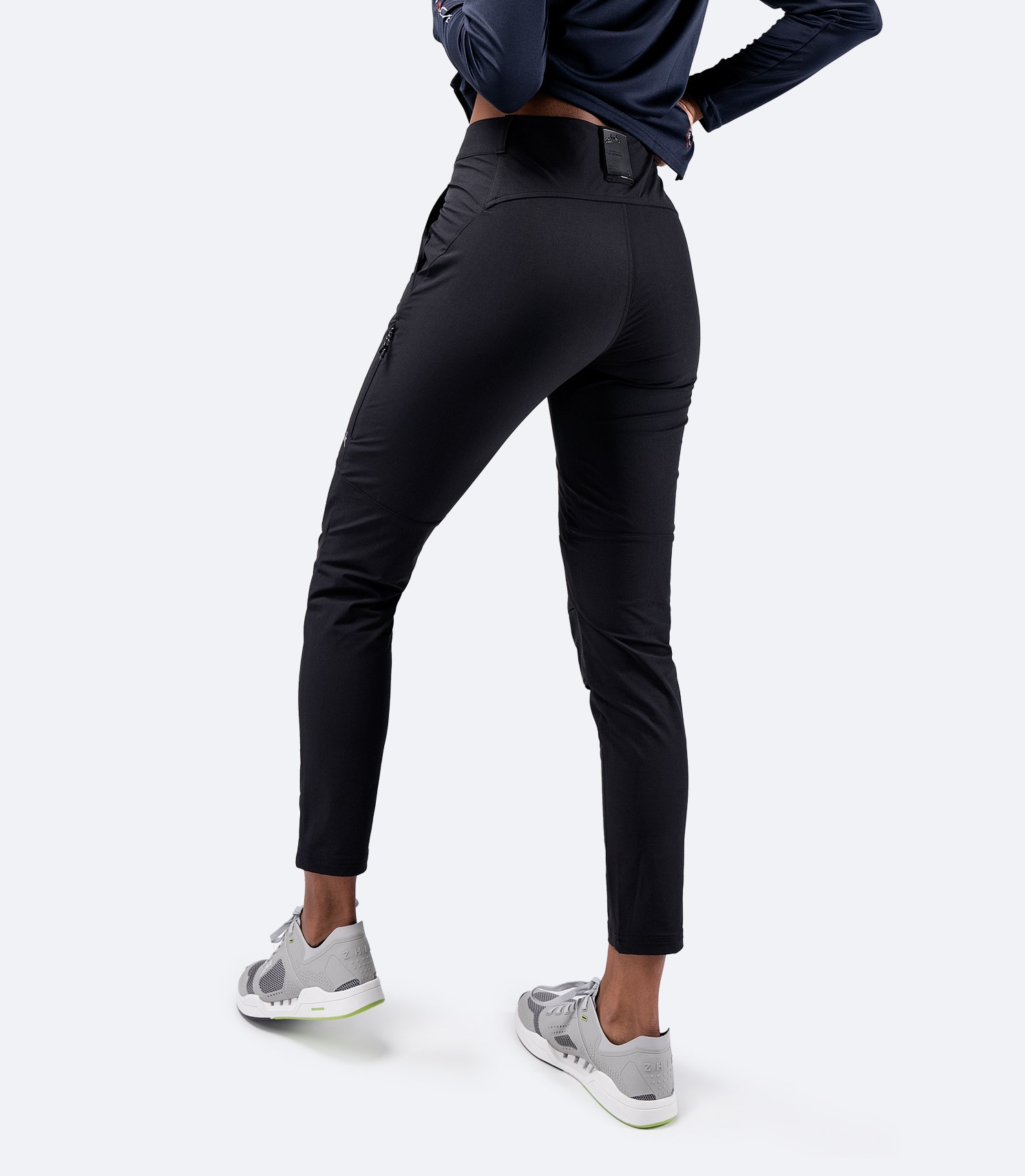 Rear view of Zhik Women's Black Deck Pant, showcasing a zippered side pocket and reinforced seat panel for durability and storage
