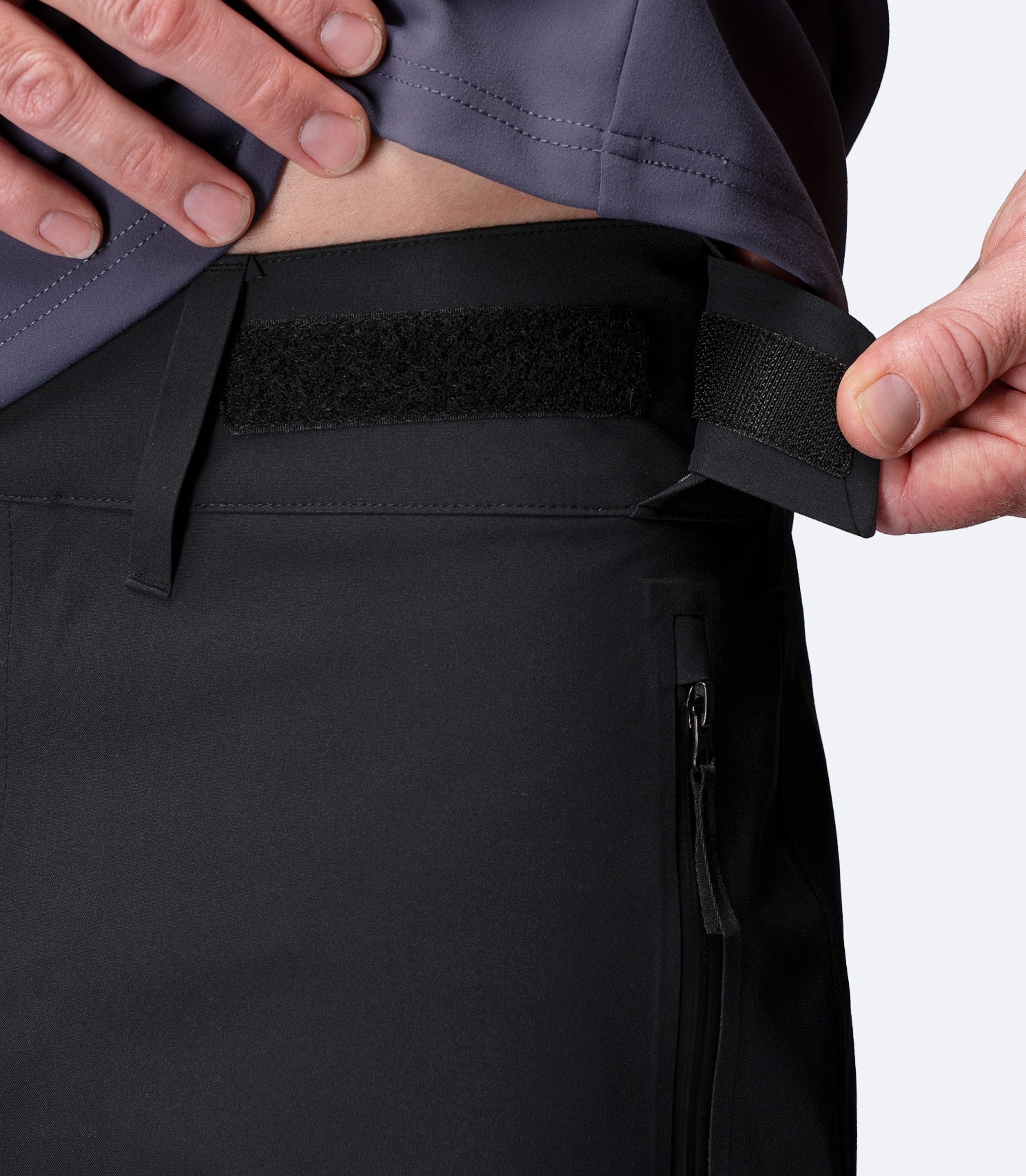 Close-up of adjustable hook and loop waist strap on Zhik Men's INS400 Inshore Performance Pant in black for a secure fit