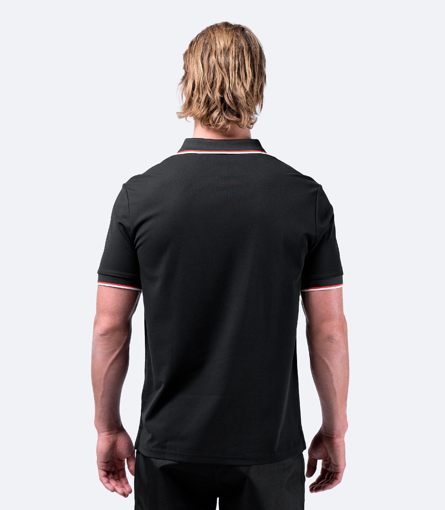 Rear view of Zhik Men's Elite Polo in black, featuring ergonomic design and breathable, lightweight pique fabric.