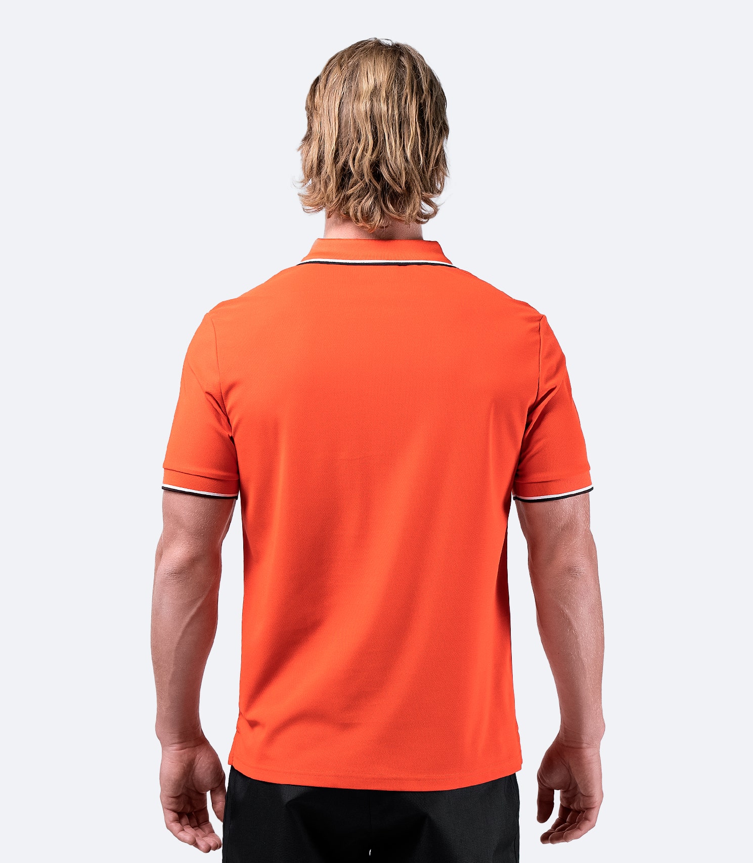 Rear view of Zhik Men's Elite Polo in ocean red, designed for movement with durable, quick-dry performance fabric.