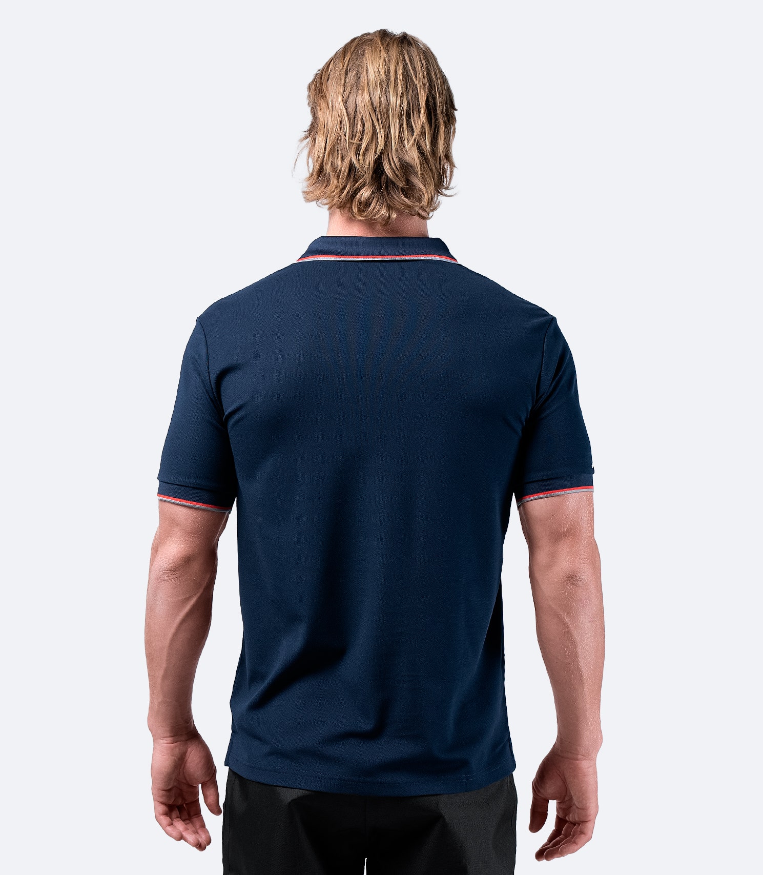 Rear view of Zhik Men's Elite Polo in navy blue, highlighting the seamless, moisture-wicking back panel for comfort.