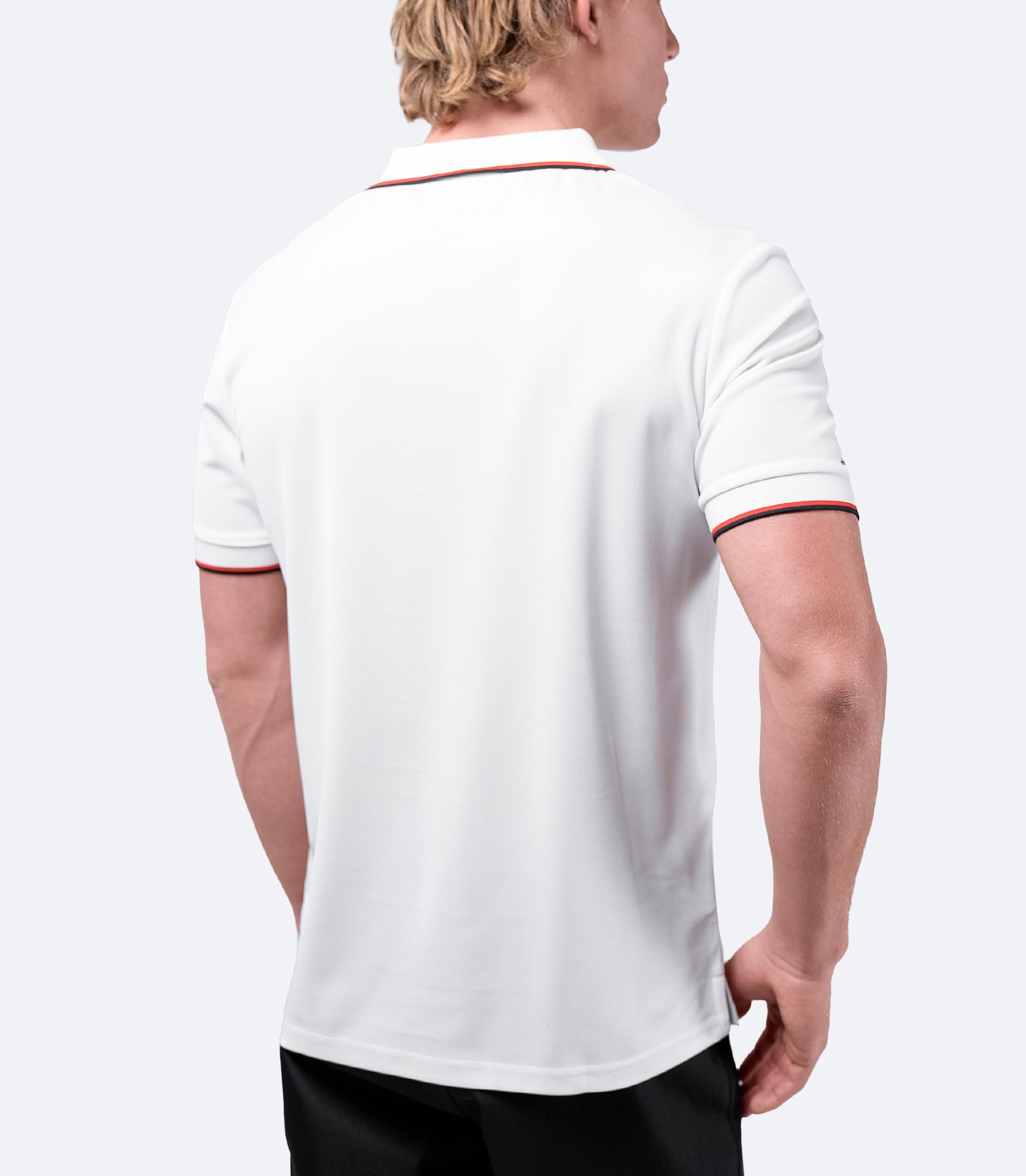 Rear view of Zhik Men's Elite Polo in white, showing ergonomic fit and breathable pique fabric for active wear.