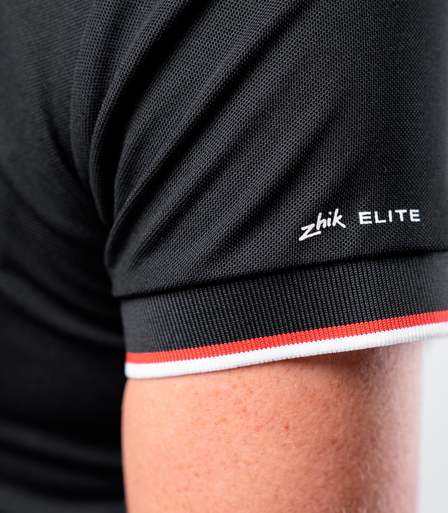 Zhik Women's Elite Polo in Black with contrast sleeve trim and lightweight 180gsm textured pique fabric.