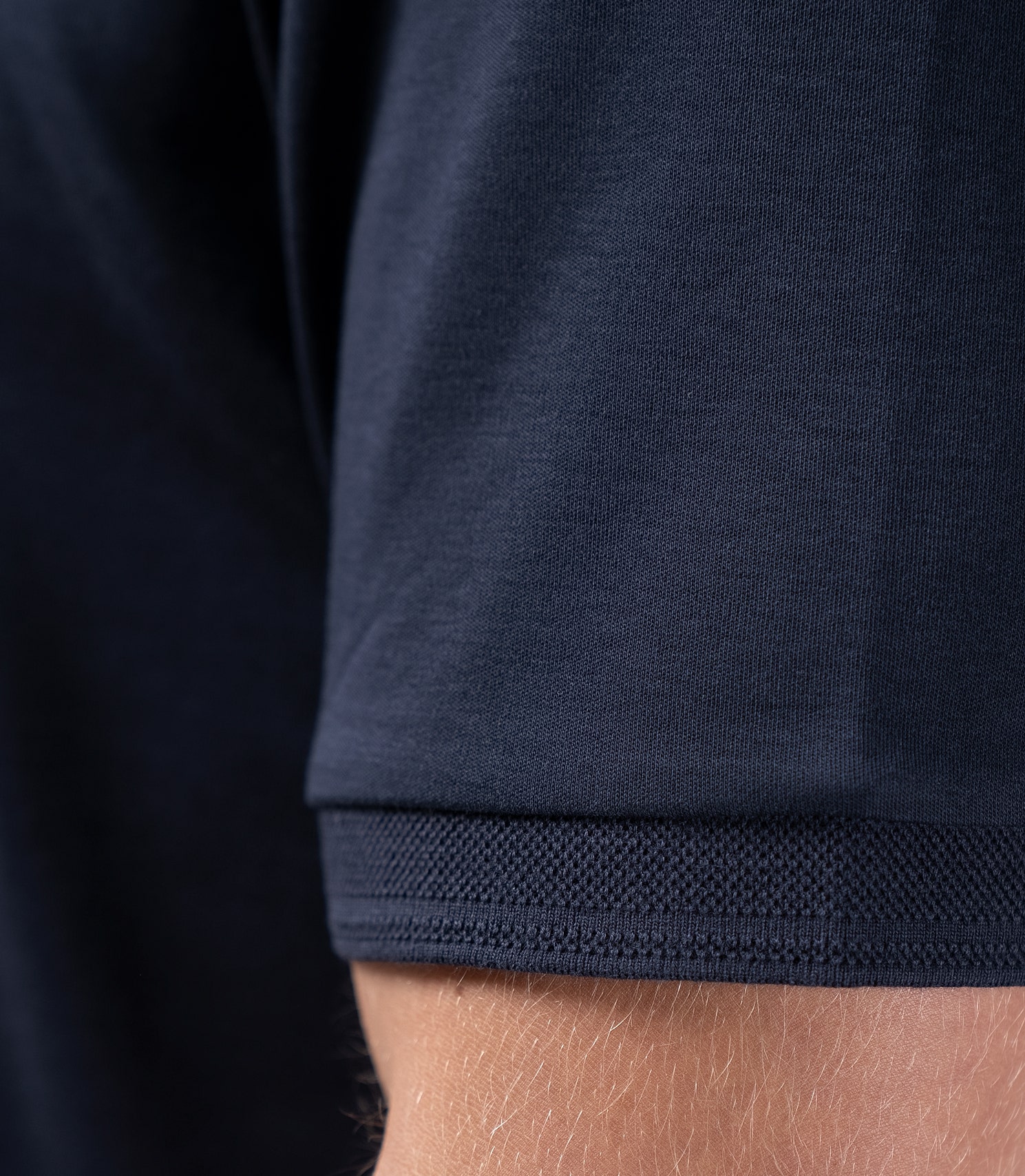 Zhik Men's Pima Cotton Polo in navy, close-up of sleeve with breathable Supima cotton and refined cuff design.
