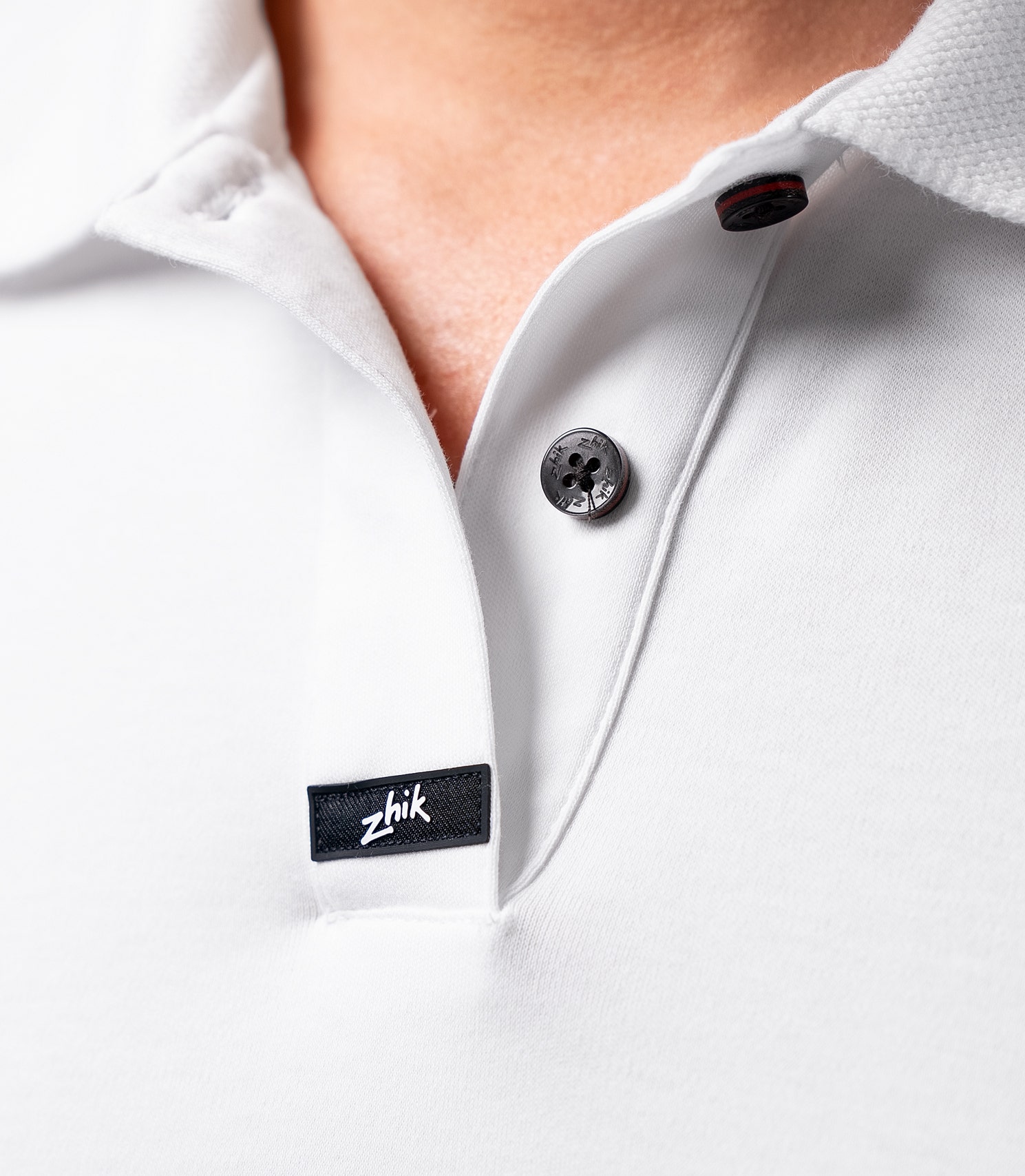 Zhik Women's Pima Cotton Polo in white, showing the textured collar, hidden button, and smooth, naturally breathable Supima cotton.