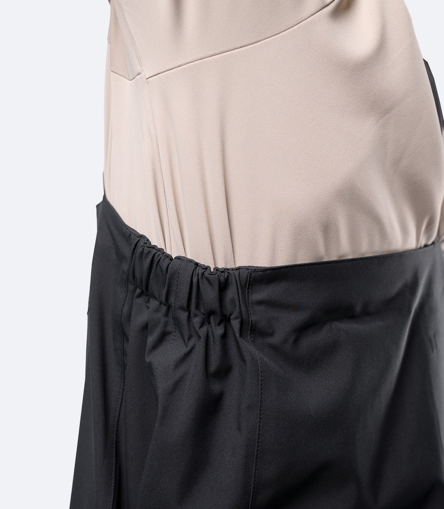 Close-up side view of Zhik INS400 black salopette, showing elastic chest panel for flexible, secure fit