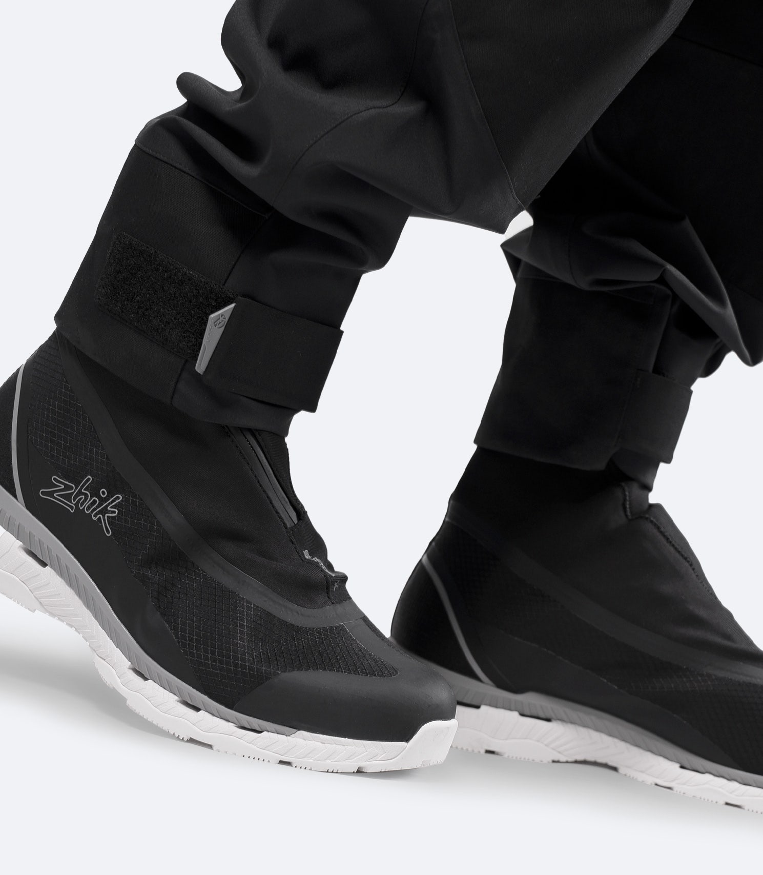 Close-up of boots with Zhik INS400 black salopette cuffs, showing adjustable leg seal over footwear