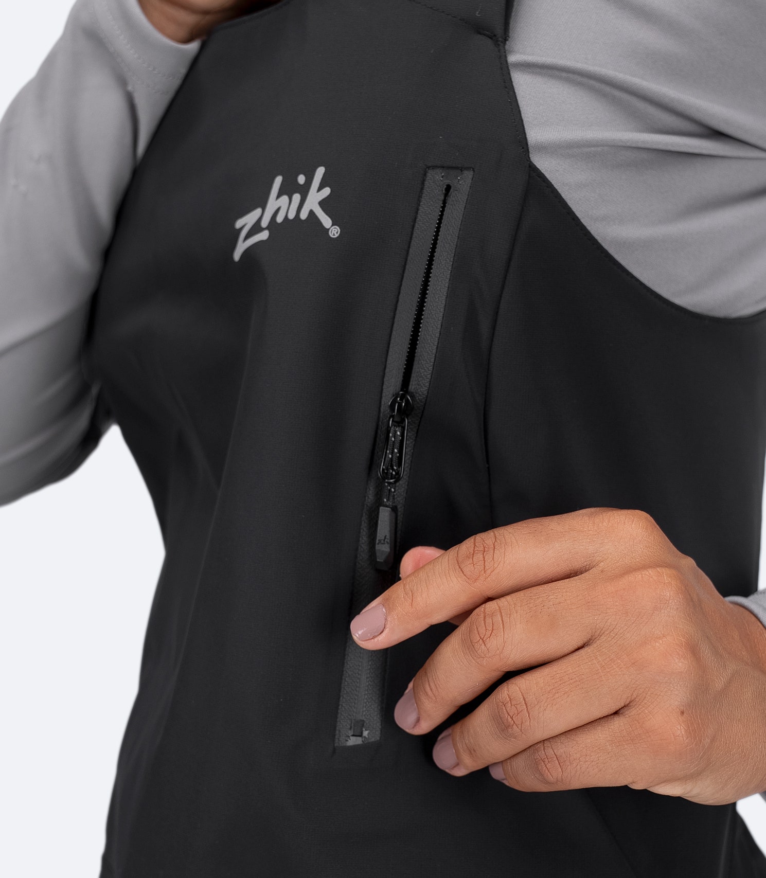 hest zipper close-up of Zhik Women's OFS700 Salopette in black with water-resistant YKK® Aquaguard® 2-way zip.