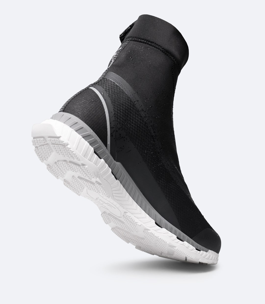 Angled rear-side view of Black Zhik Surge X waterproof shoe with toe on deck showing grippy sole and raised gaiter