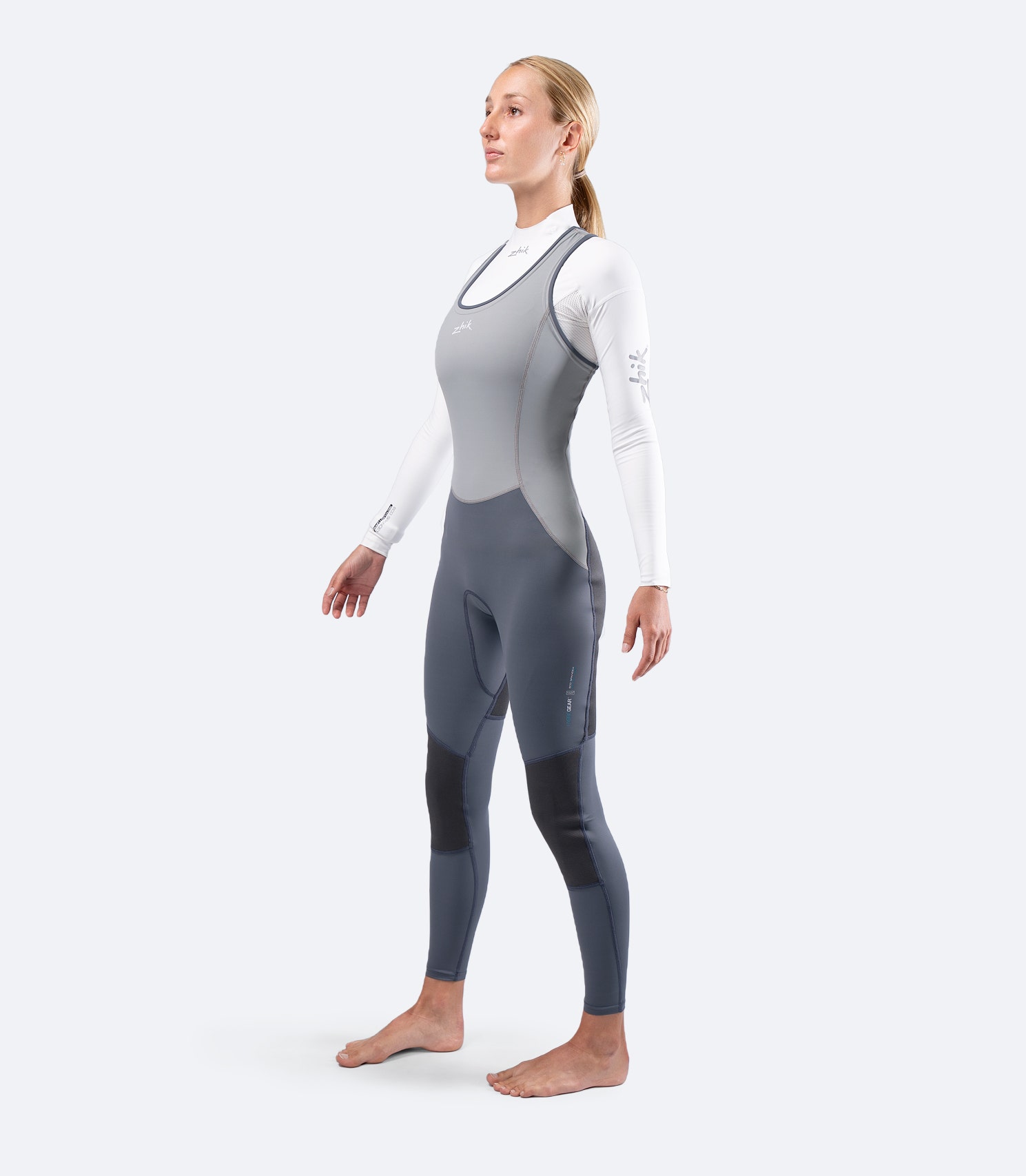 Front diagonal view of Zhik Women's Hybrid Gear Performance Skiff Suit in grey, showing articulated fit and long jane cut.