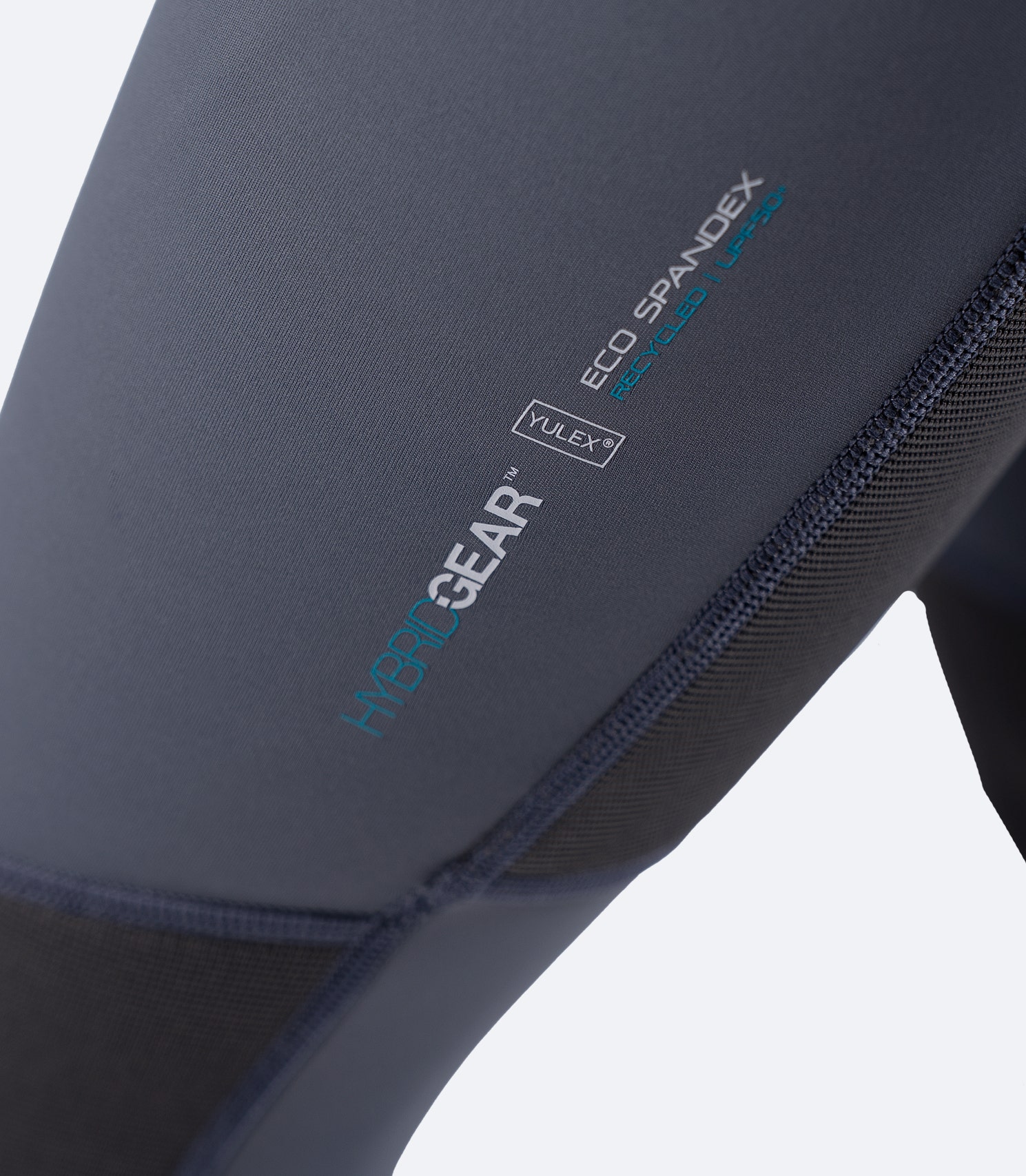 Close-up of Zhik Hybrid Gear thigh branding on the grey skiff suit, showing Eco Spandex and Yulex® logo detail.