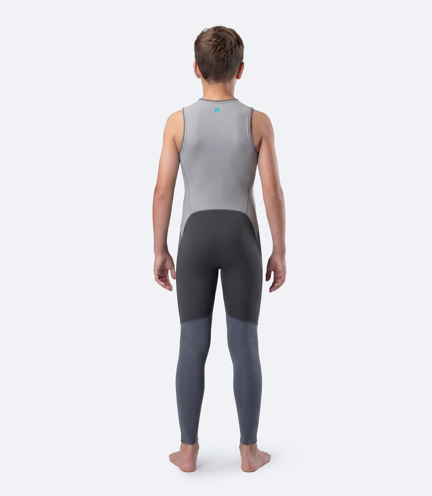 Rear view of Zhik Youth Hybrid Gear Performance Skiff Suit in Grey on male model, showing reinforced seat and strap layout