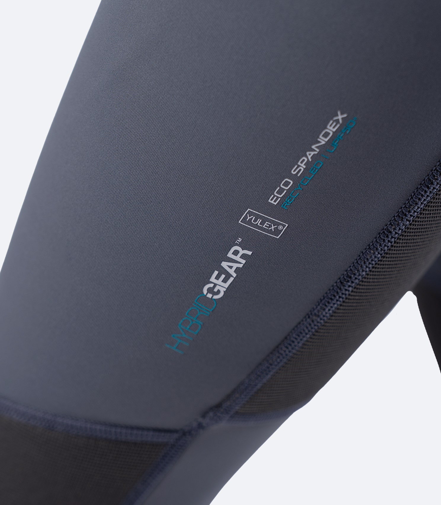 Close-up of Zhik Youth Hybrid Gear Performance Skiff Suit in Grey showing HybridGear Eco Spandex and Yulex logo on thigh